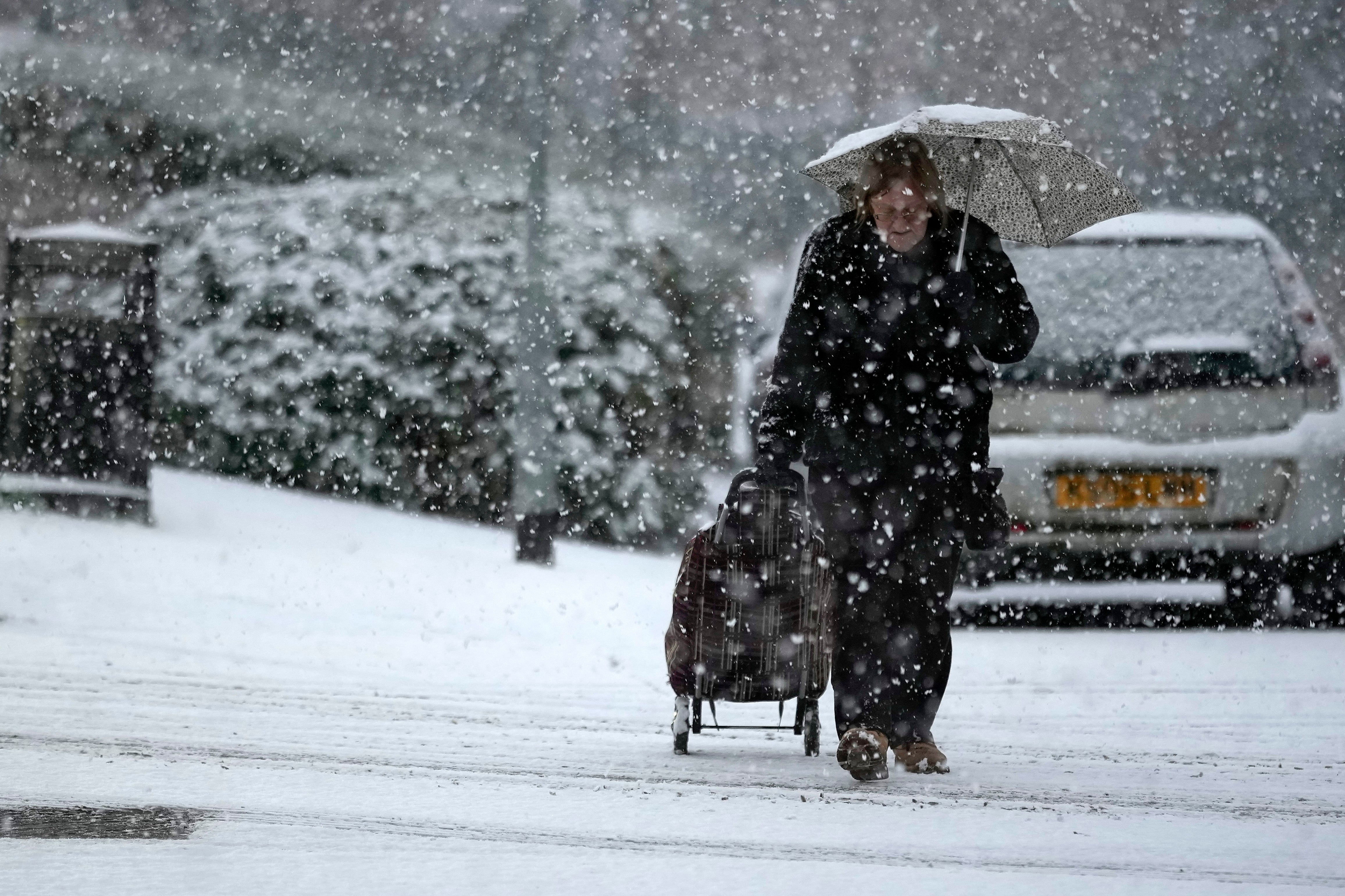 A woman makes her way through a snow flurry in Cheshire