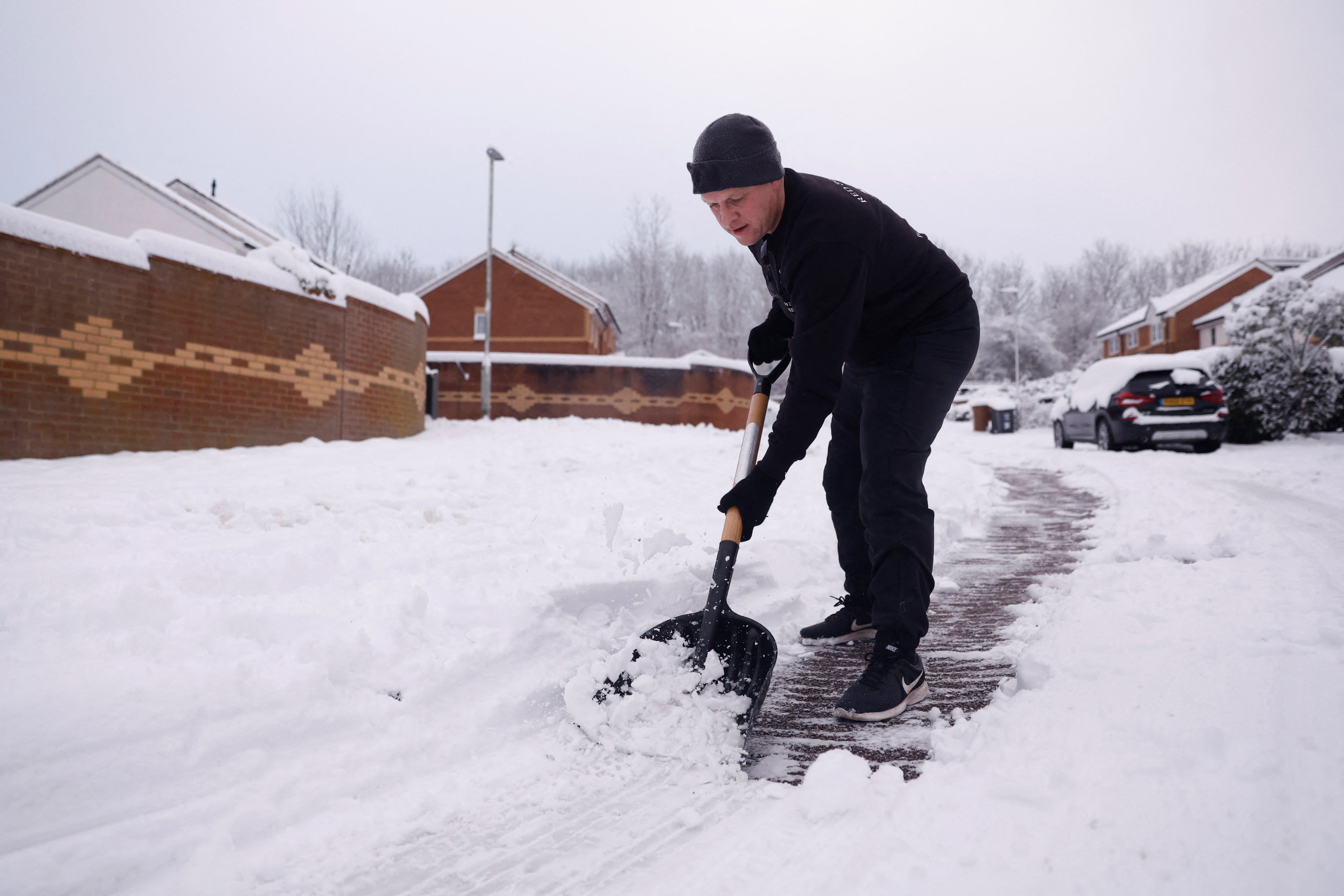 A man clears snow in Hertford, England