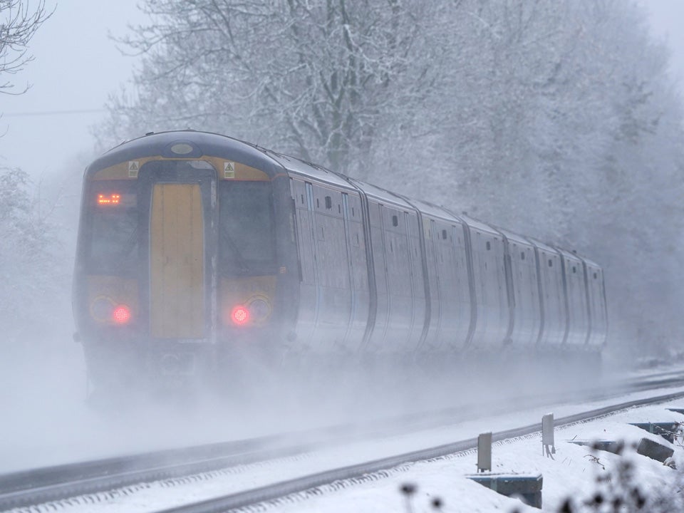 A Southeastern train makes its way through Ashford in Kent as rail services remain disrupted in the COLD weather