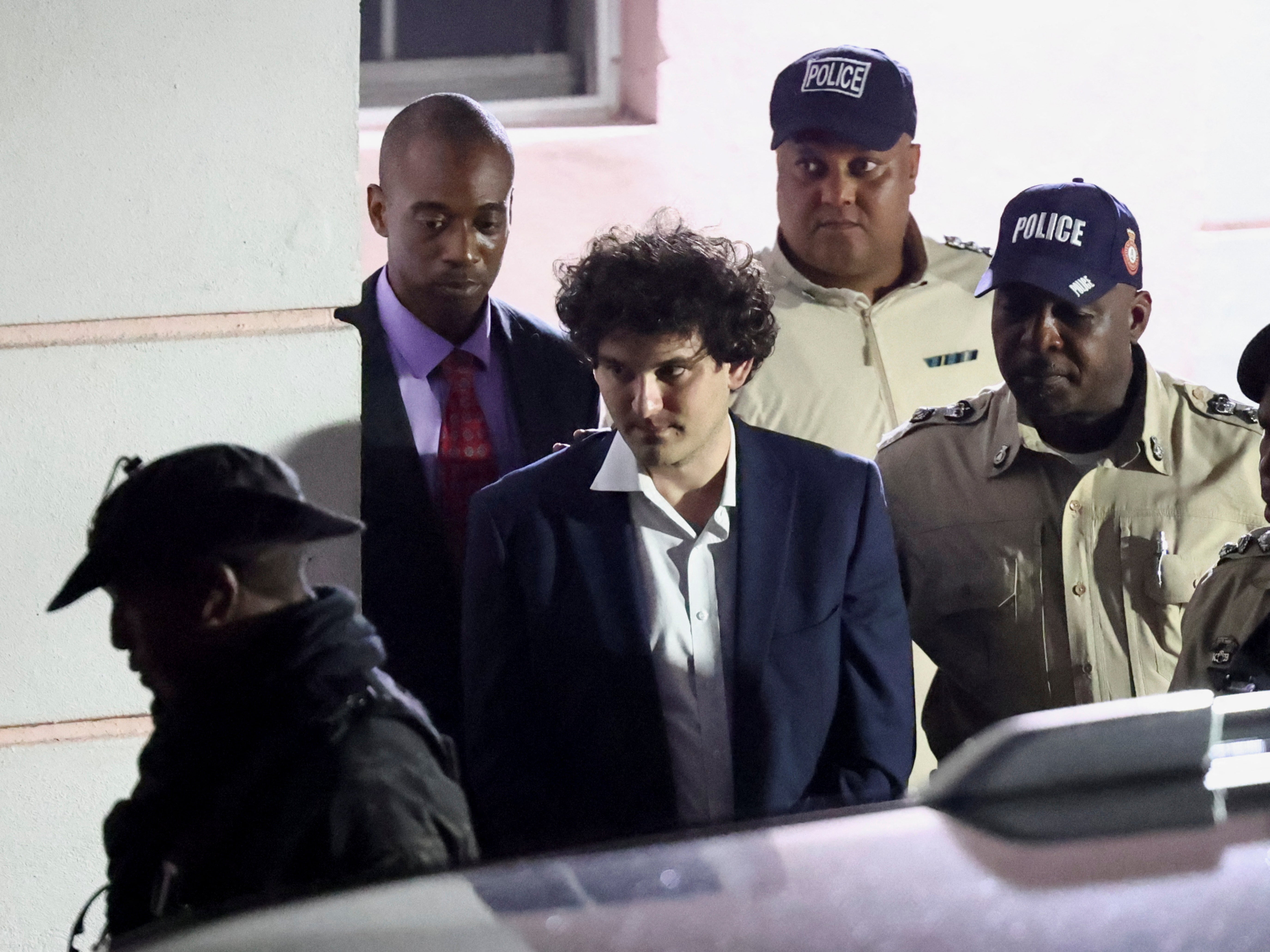 Sam Bankman-Fried is escorted out of the Magistrate Court building after his arrest, in Nassau, Bahamas December 13, 2022