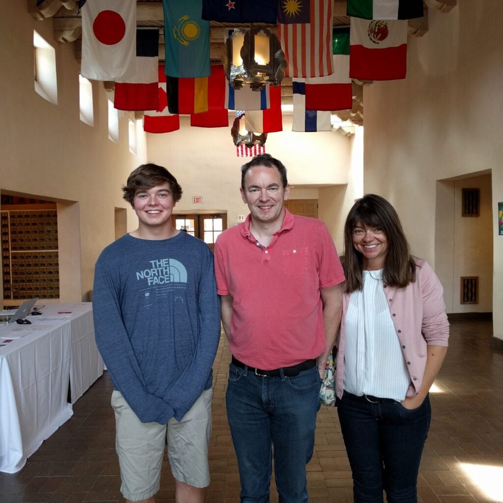 Christian Glass smiles with his parents, Sally and Simon Glass, from England and New Zealand, respectively