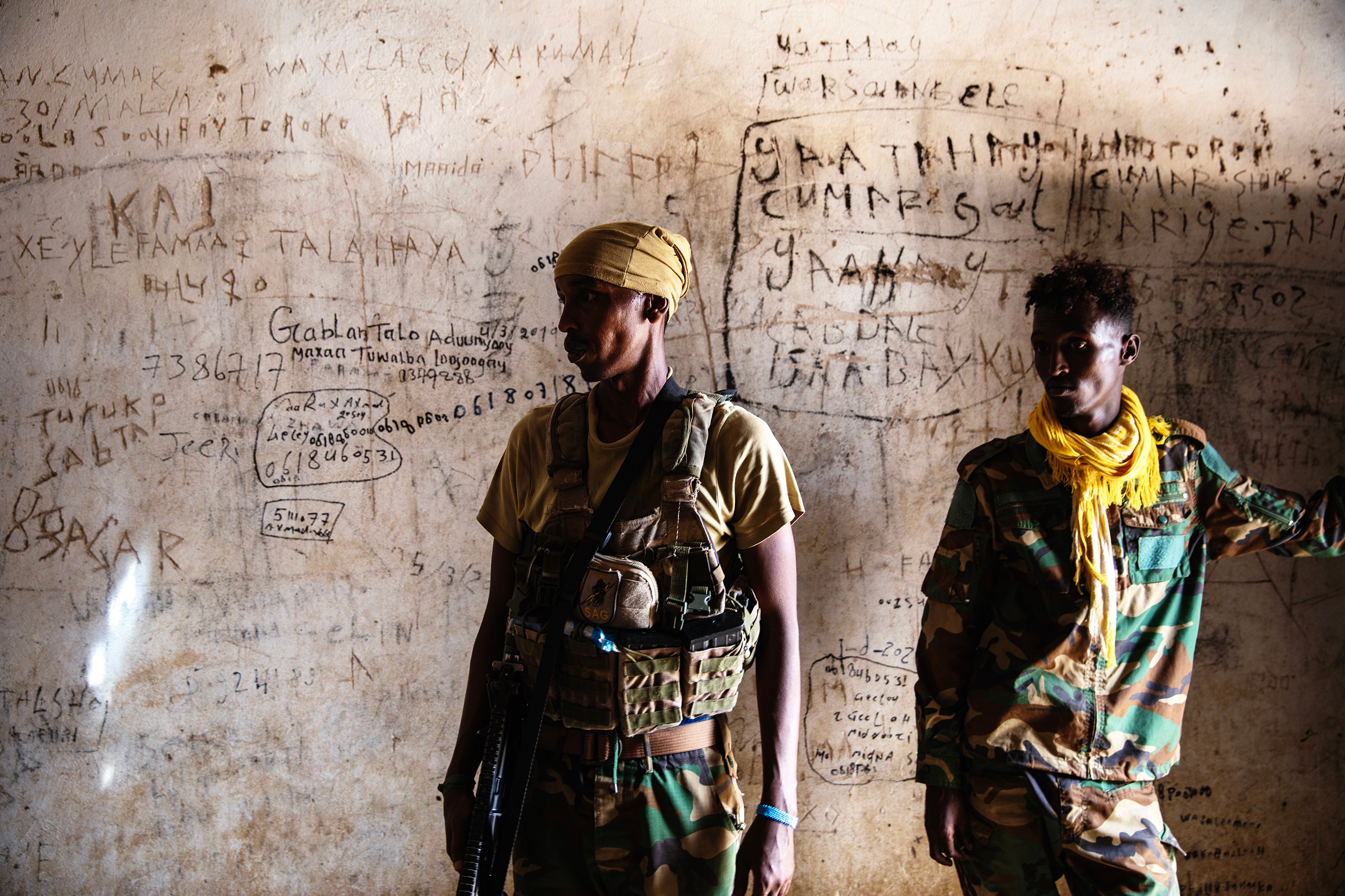 Soldiers stand in an empty jail where al-Shabab is believed to have imprisoned people