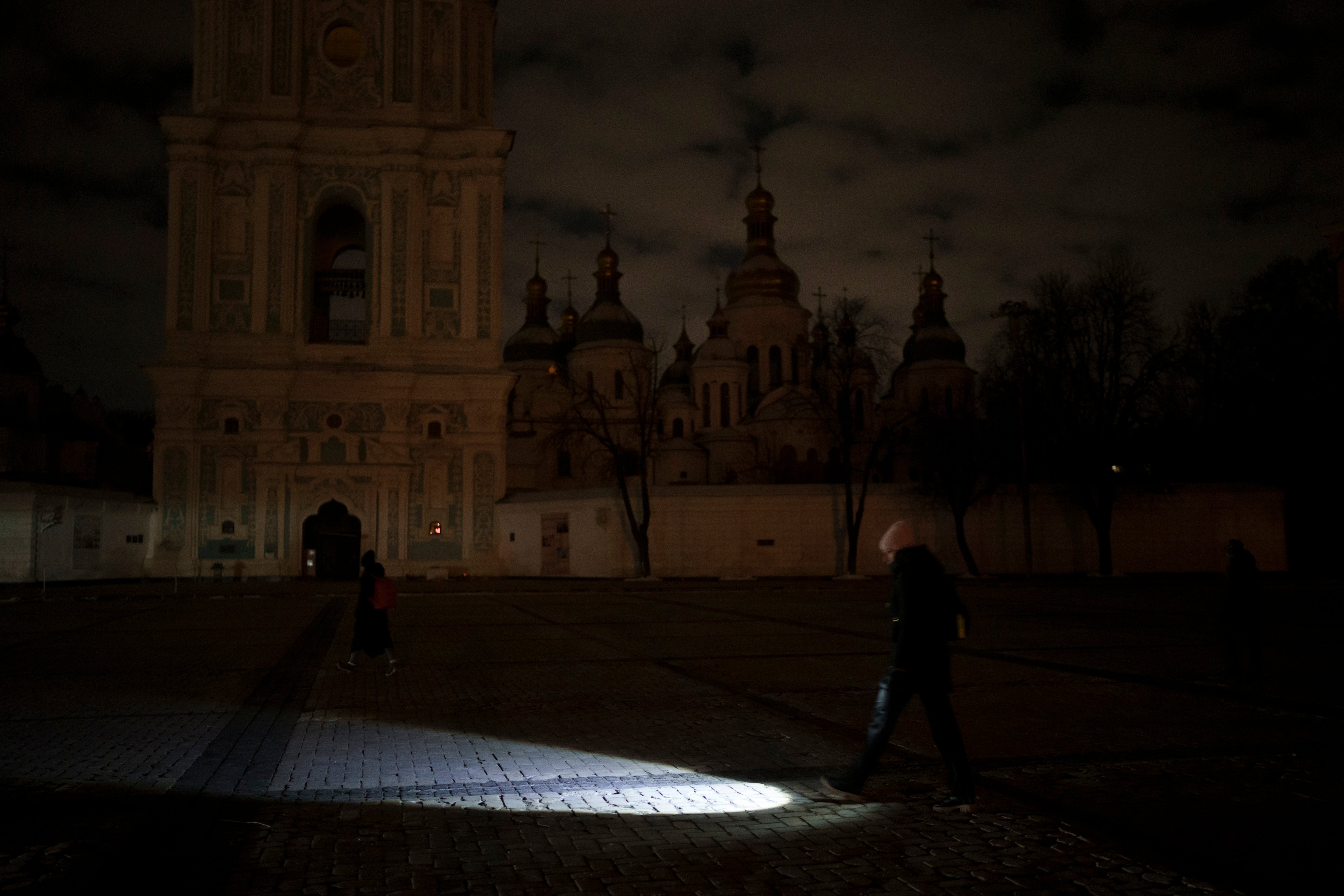 Russia’s shelling of Ukraine caused power outages across the country. Here a woman is walking with a torch during the blackout.