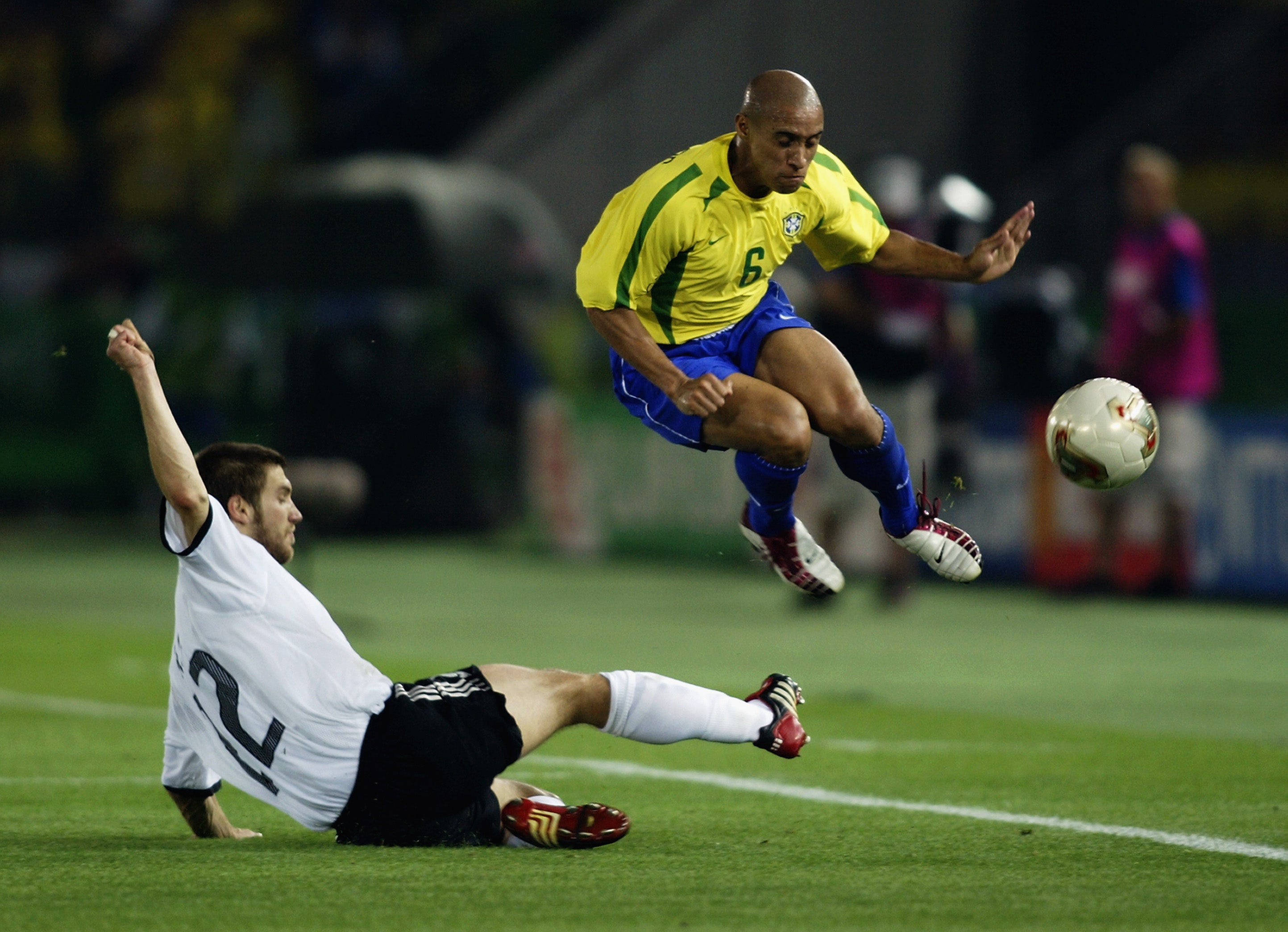 Roberto Carlos skips over a sliding challenge by Torsten Frings