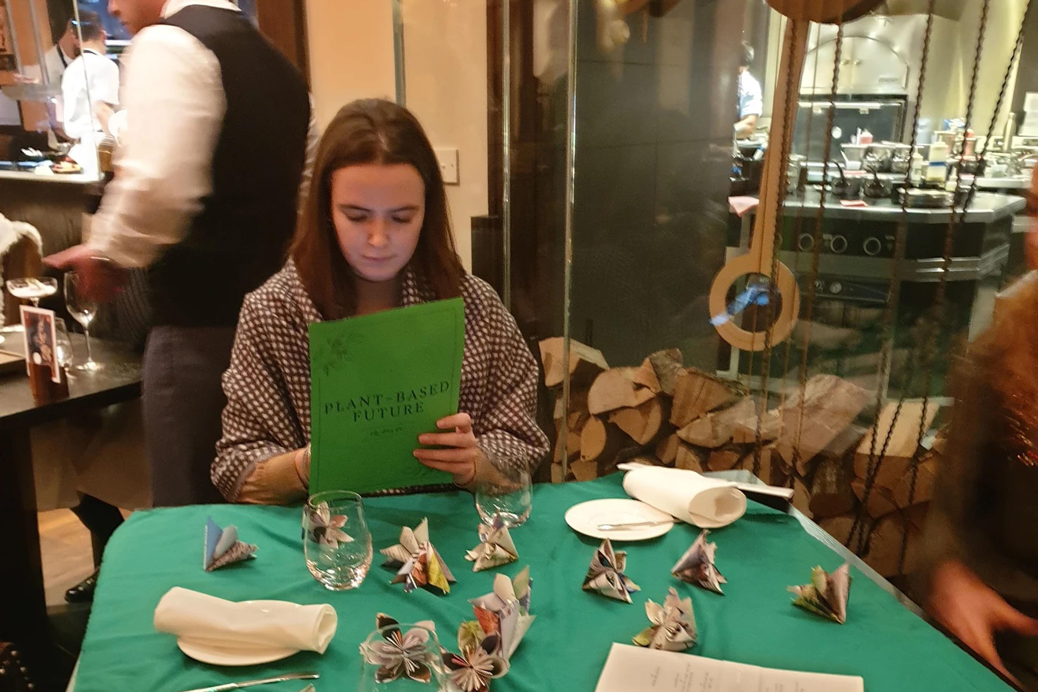 Activists from Animal Rebellion holding green menus during a protest in Heston Blumenthal’s restaurant in London (Animal Rebellion/PA)