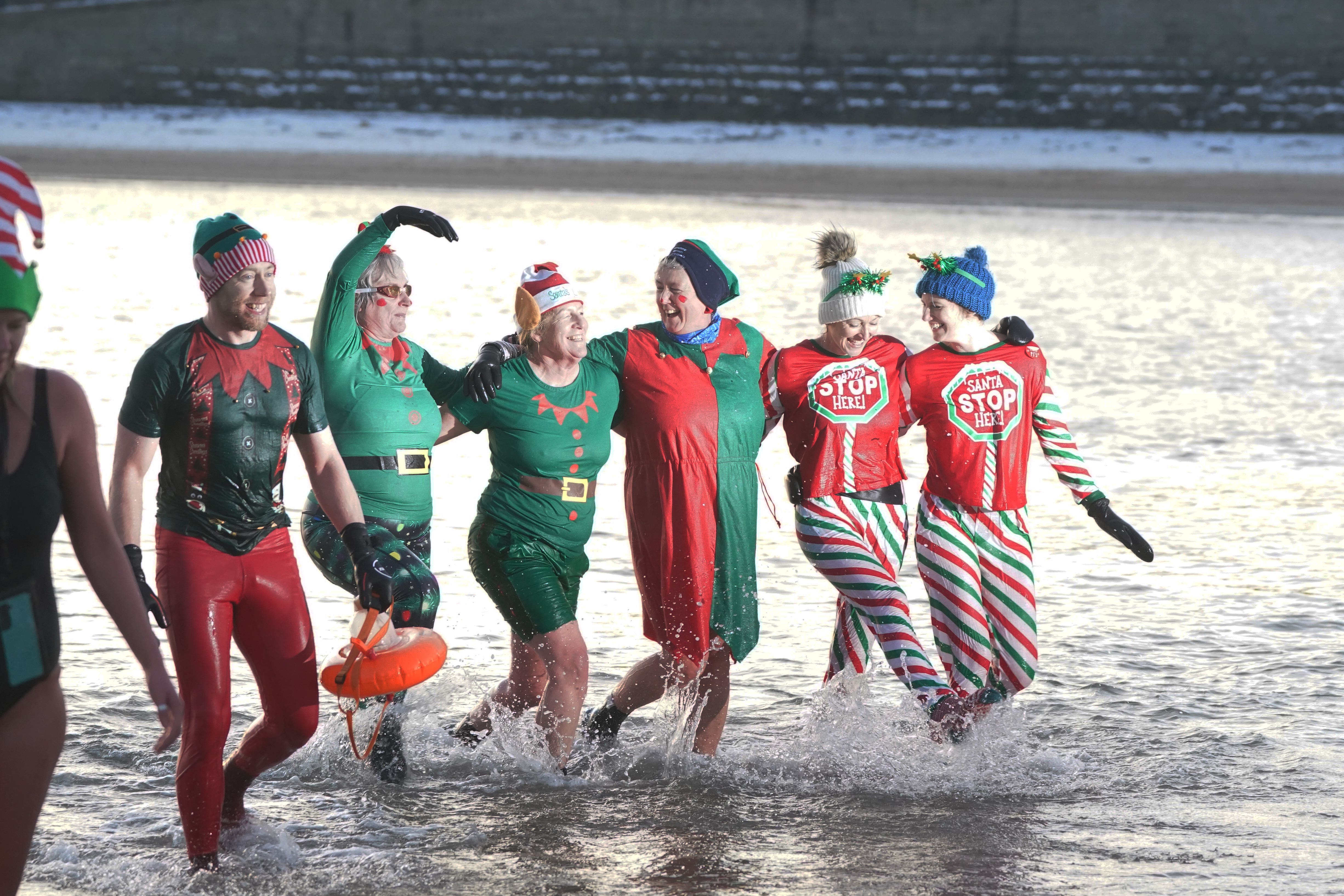 Cold water swimmers on the beach at Cullercoats Bay on the North East coast. Snow and ice have swept across parts of the UK, with cold wintry conditions set to continue for days. Picture date: Saturday December 17, 2022.