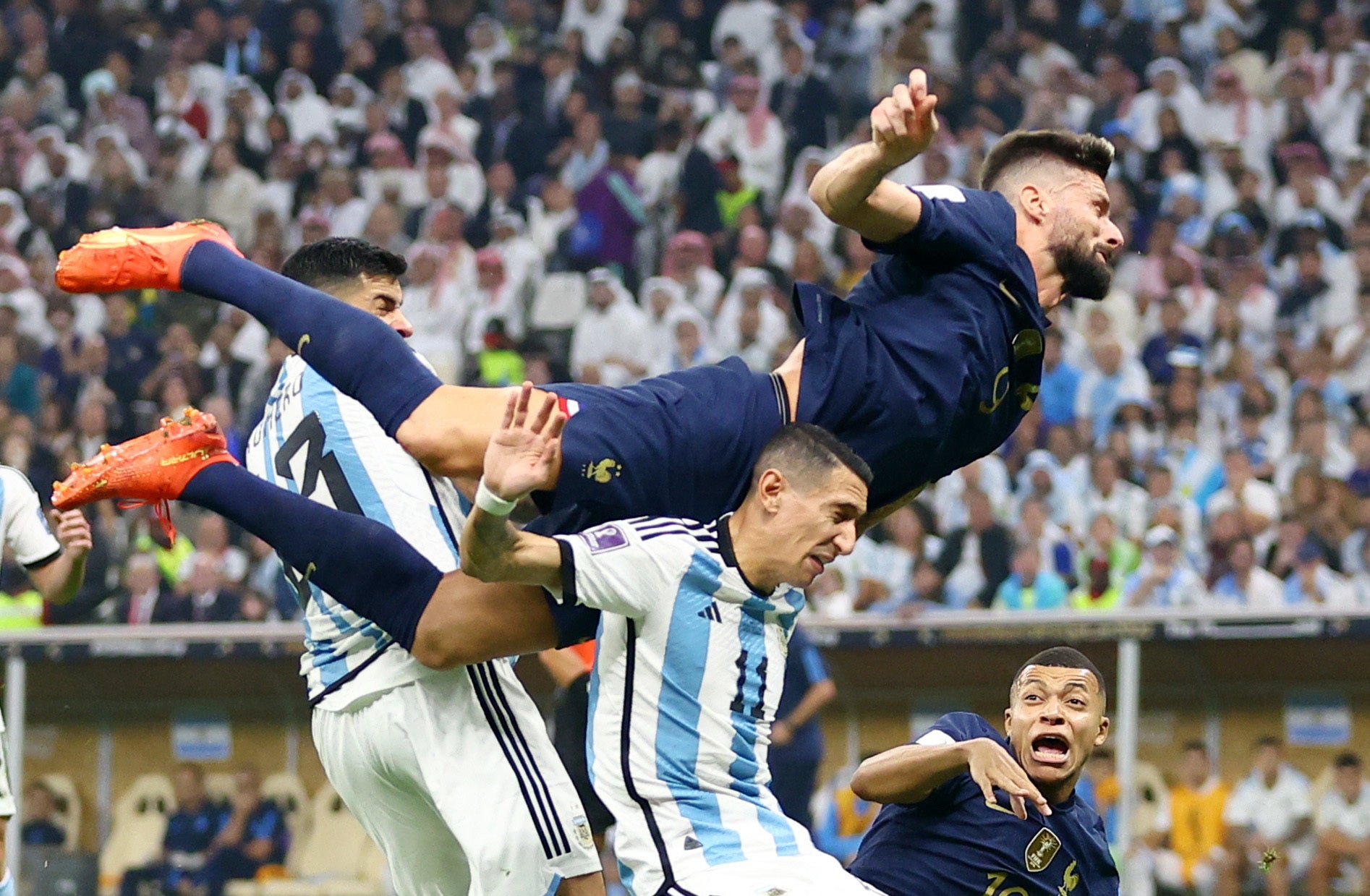 Olivier Giroud jumps over Angel Di Maria to head the ball