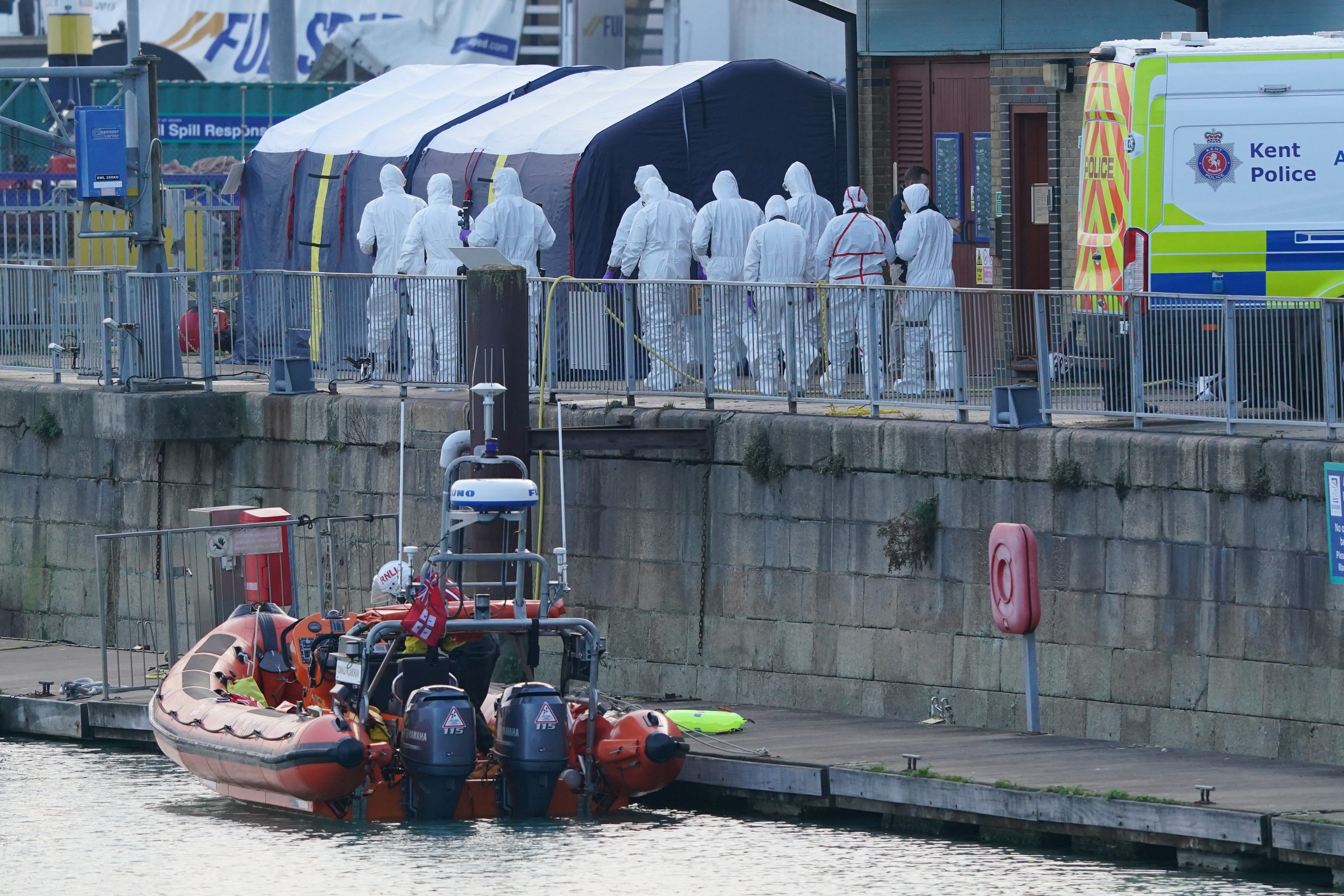 Forensic officers head to the forensic tents erected at the RNLI station at the Port of Dover