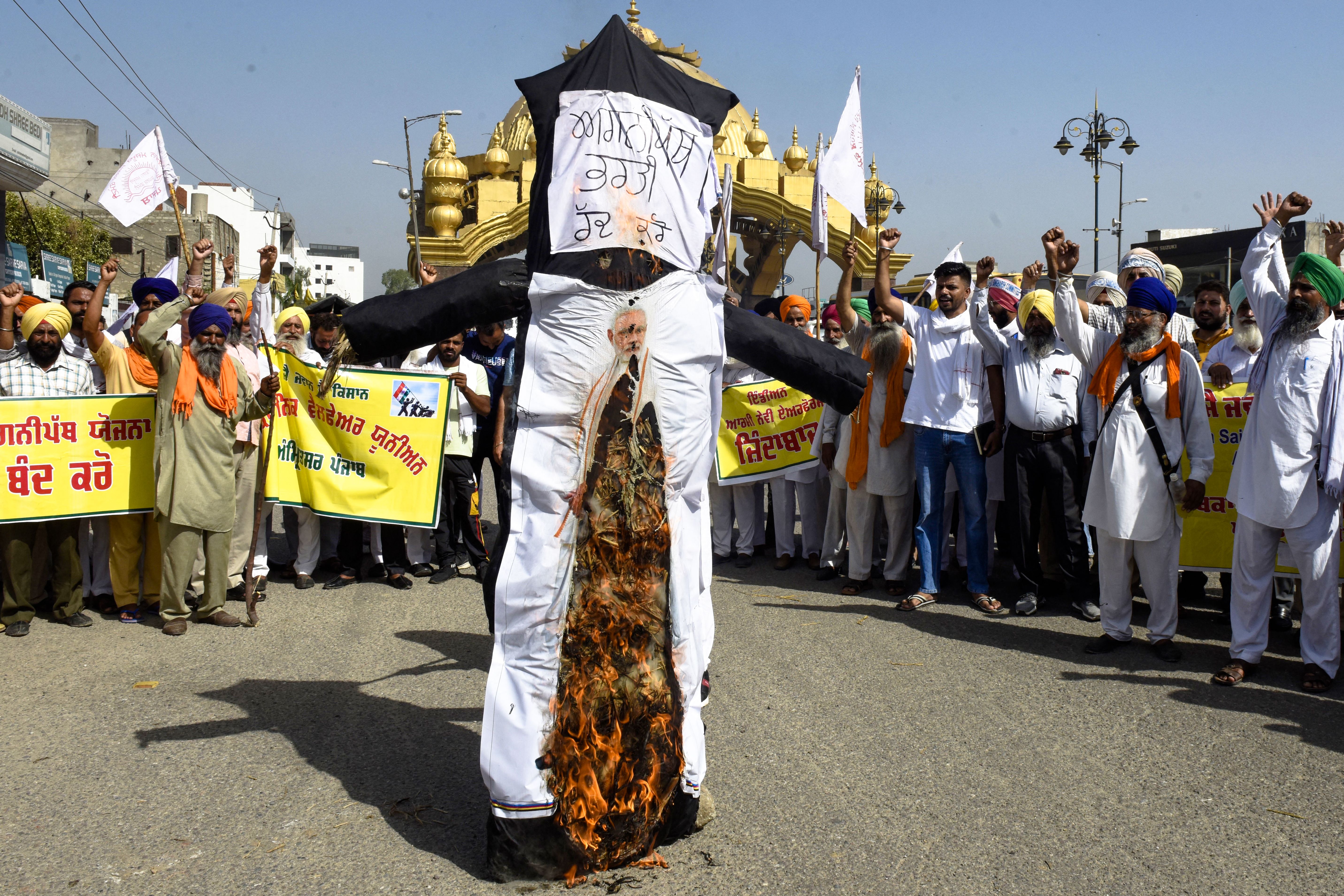 Demonstrators shout slogans as they burn an effigy of India’s prime minister Narendra Modi during a protest against the government’s new ‘Agnipath’ recruitment scheme for the army, navy, and air forces on the outskirts of Amritsar on 24 June 2022