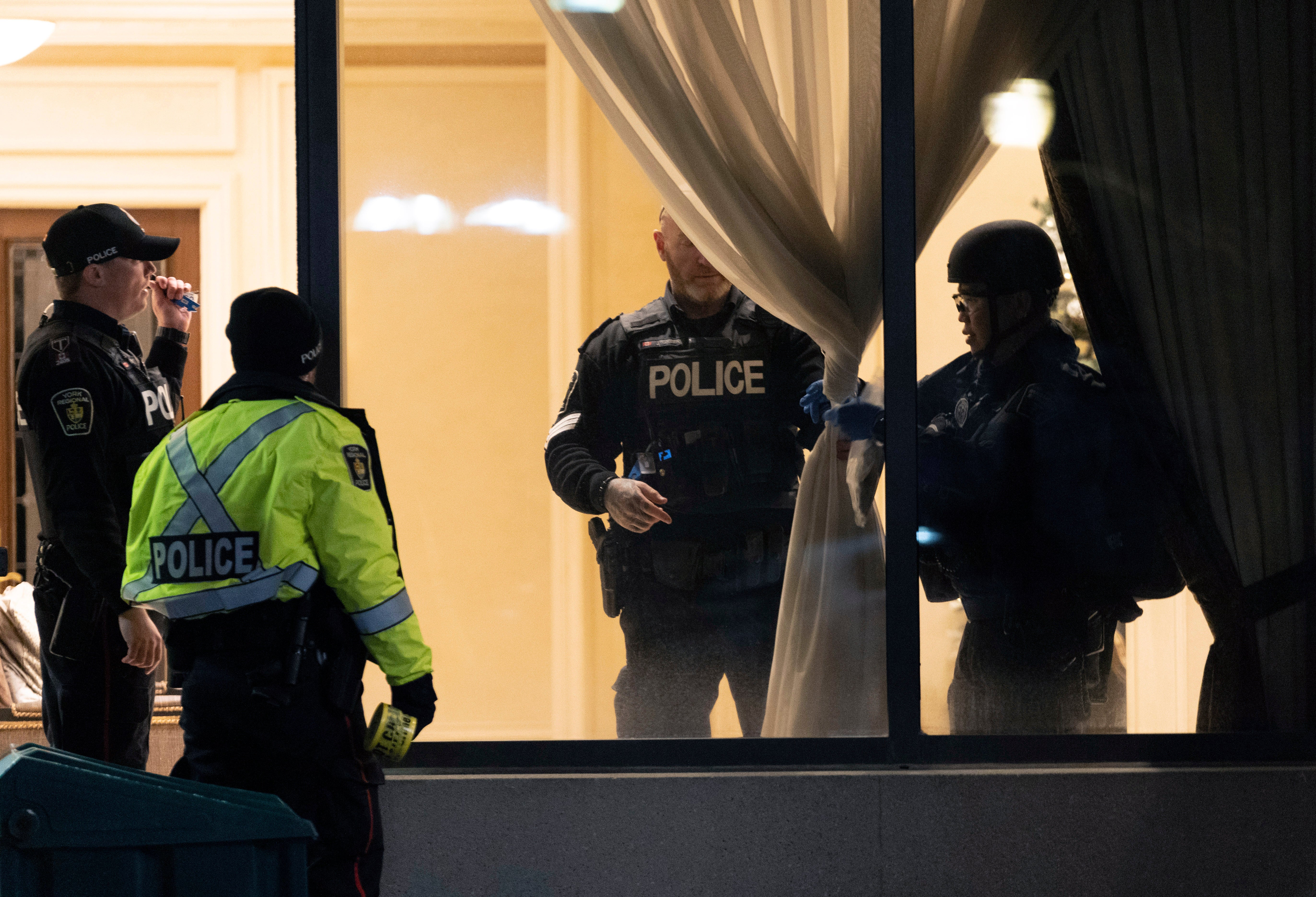 Police stand in the lobby of a condominium building following a shooting in Vaughan