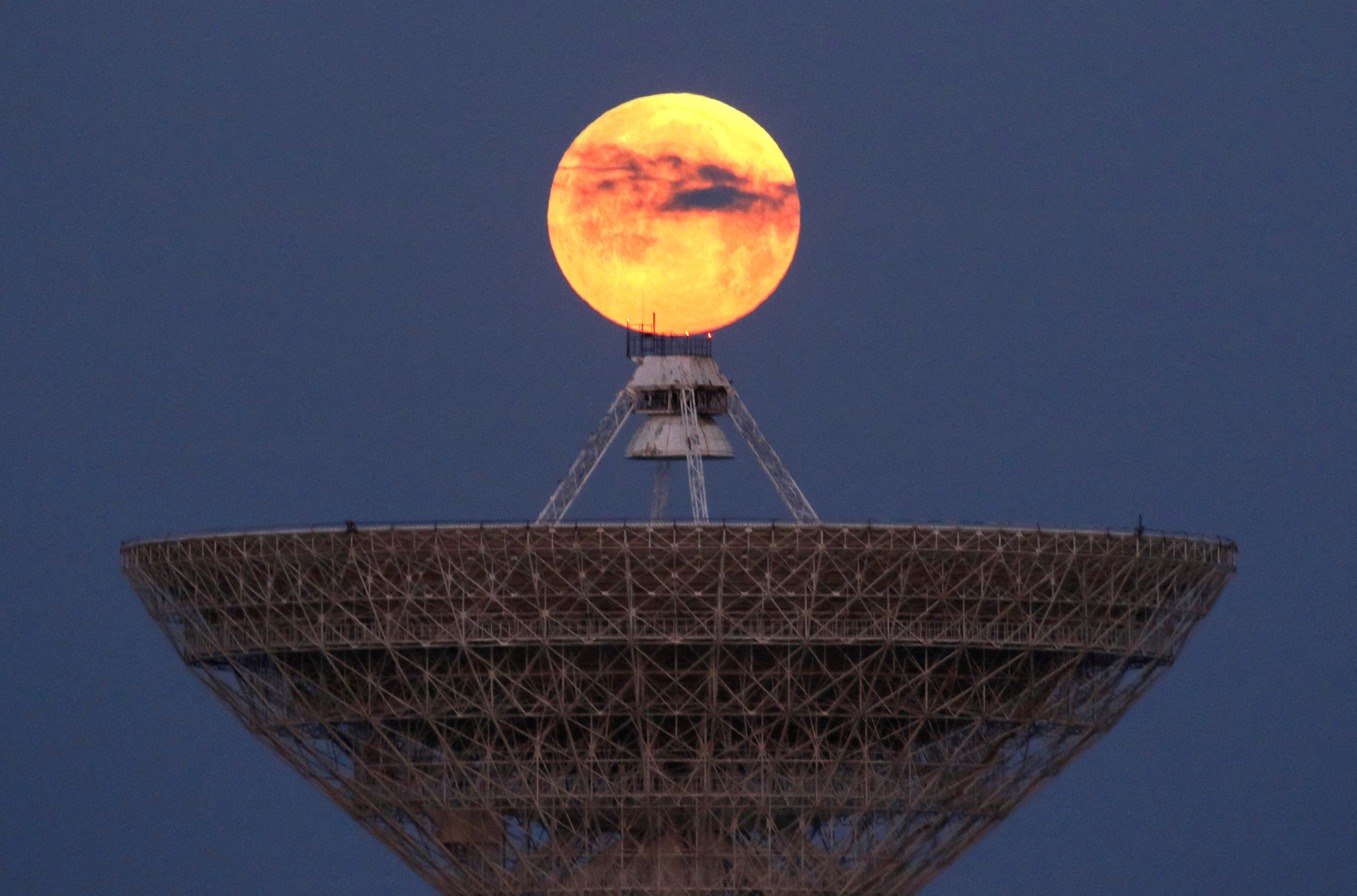 The moon seen through clouds behind the radio telescope RT-70 in the village of Molochnoye, Crimea