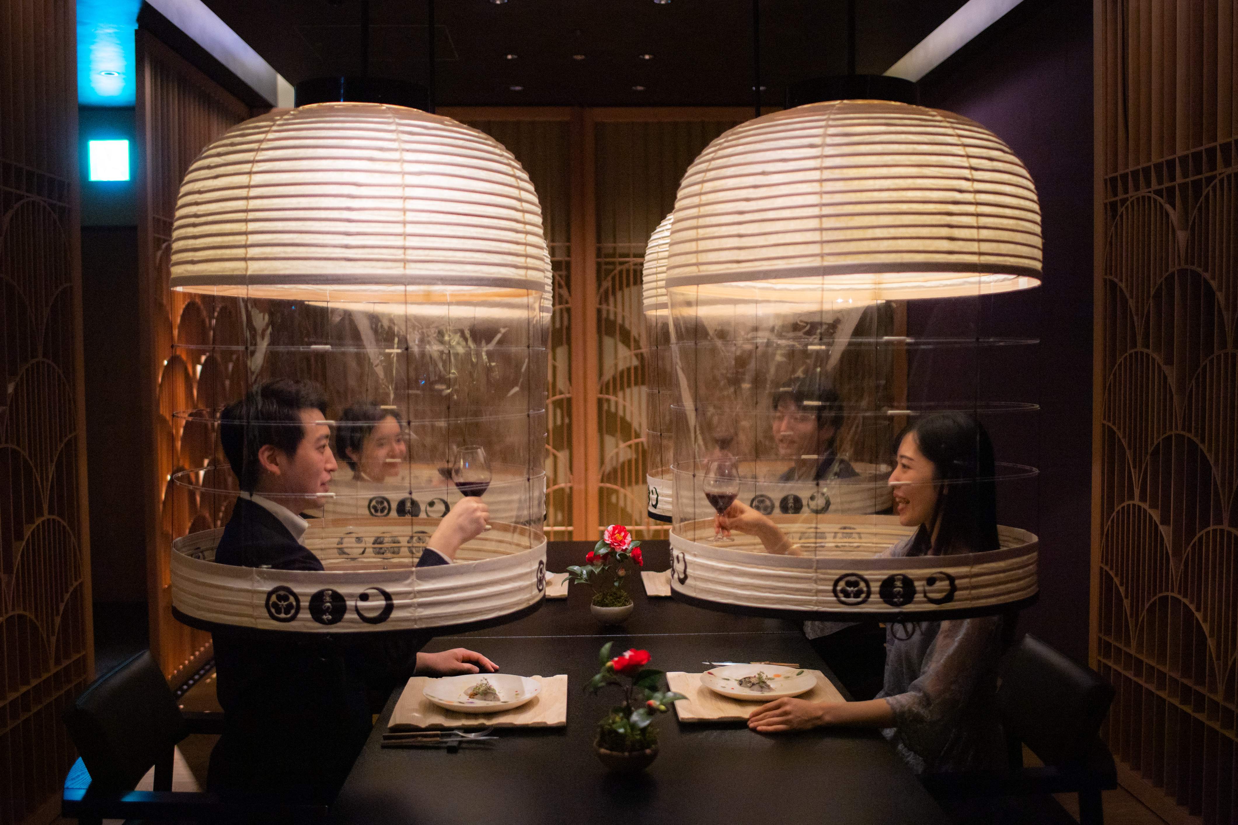 Staff members from the Hoshinoya Tokyo hotel demonstrate the “Lantern Dining Experience”, where lanterns made by Kojima Shoten - a shop in Kyoto - are used to shroud diners for mask-free dining amid the coronavirus pandemic