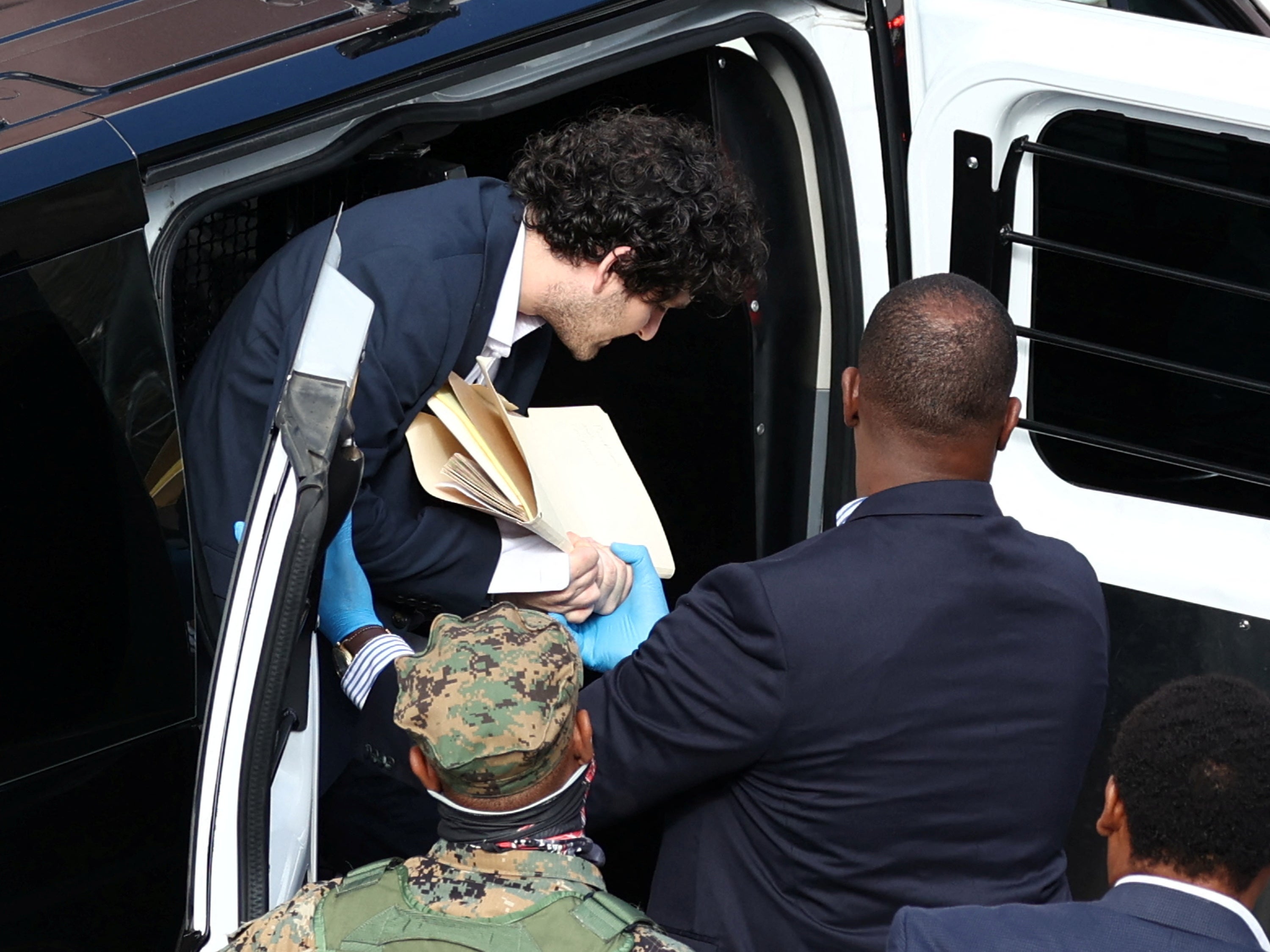 Sam Bankman-Fried is escorted into the court building in Nassau, Bahamas on Monday