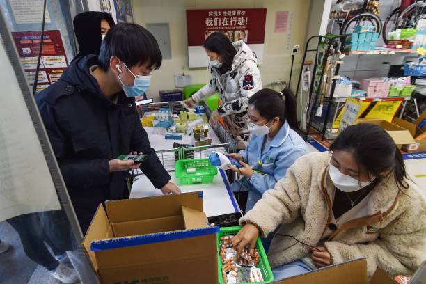 A man buys fever medicine at a pharmacy amid the Covid-19 pandemic in Nanjing, in China’s eastern Jiangsu province, on 19 December2022, as the pharmacy offers six capsules for each client