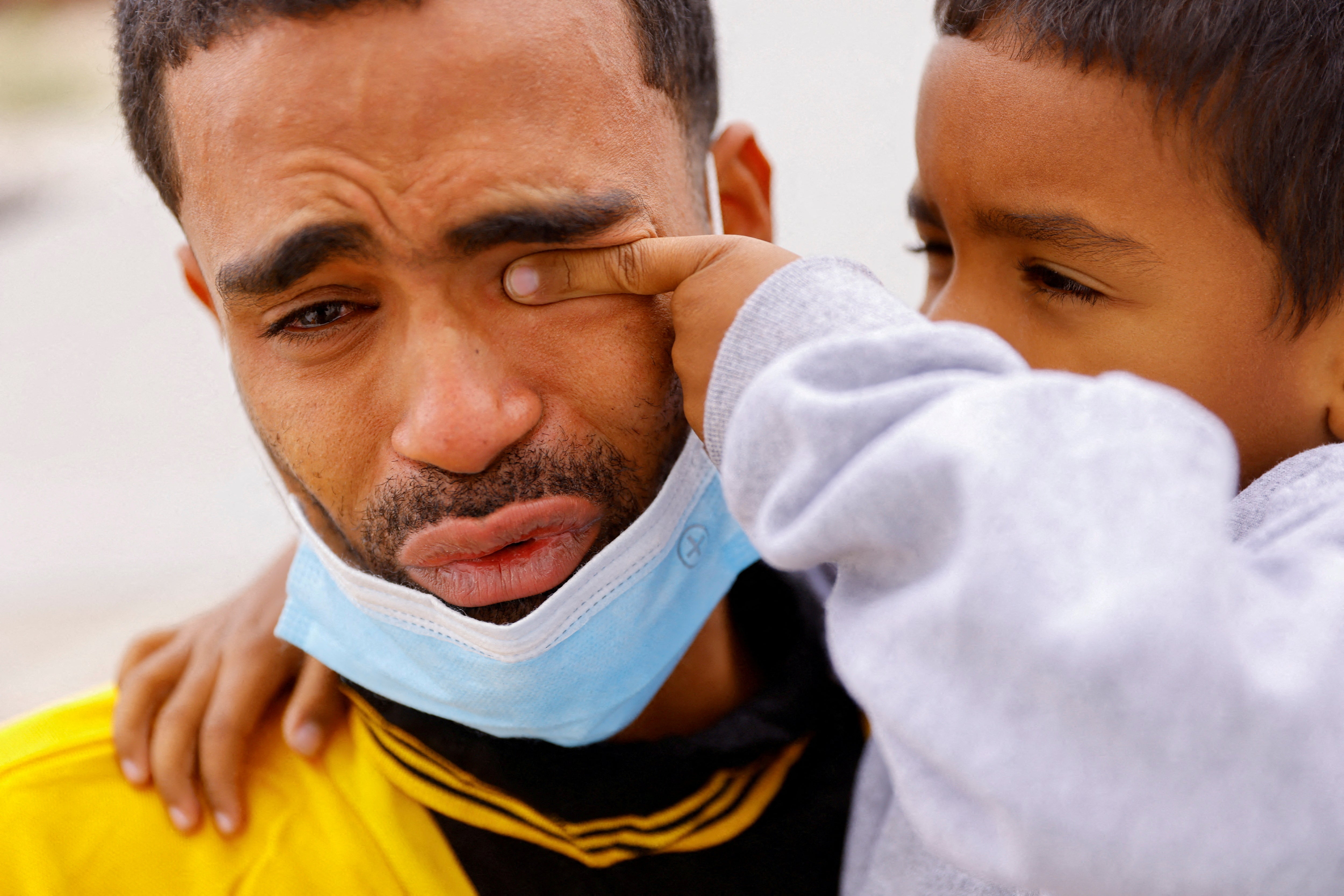 Saul wipes the tears of his father Franklin, after they were expelled from the US and sent back to Mexico under Title 42, near the Paso del Norte International border bridge, in Ciudad Juarez