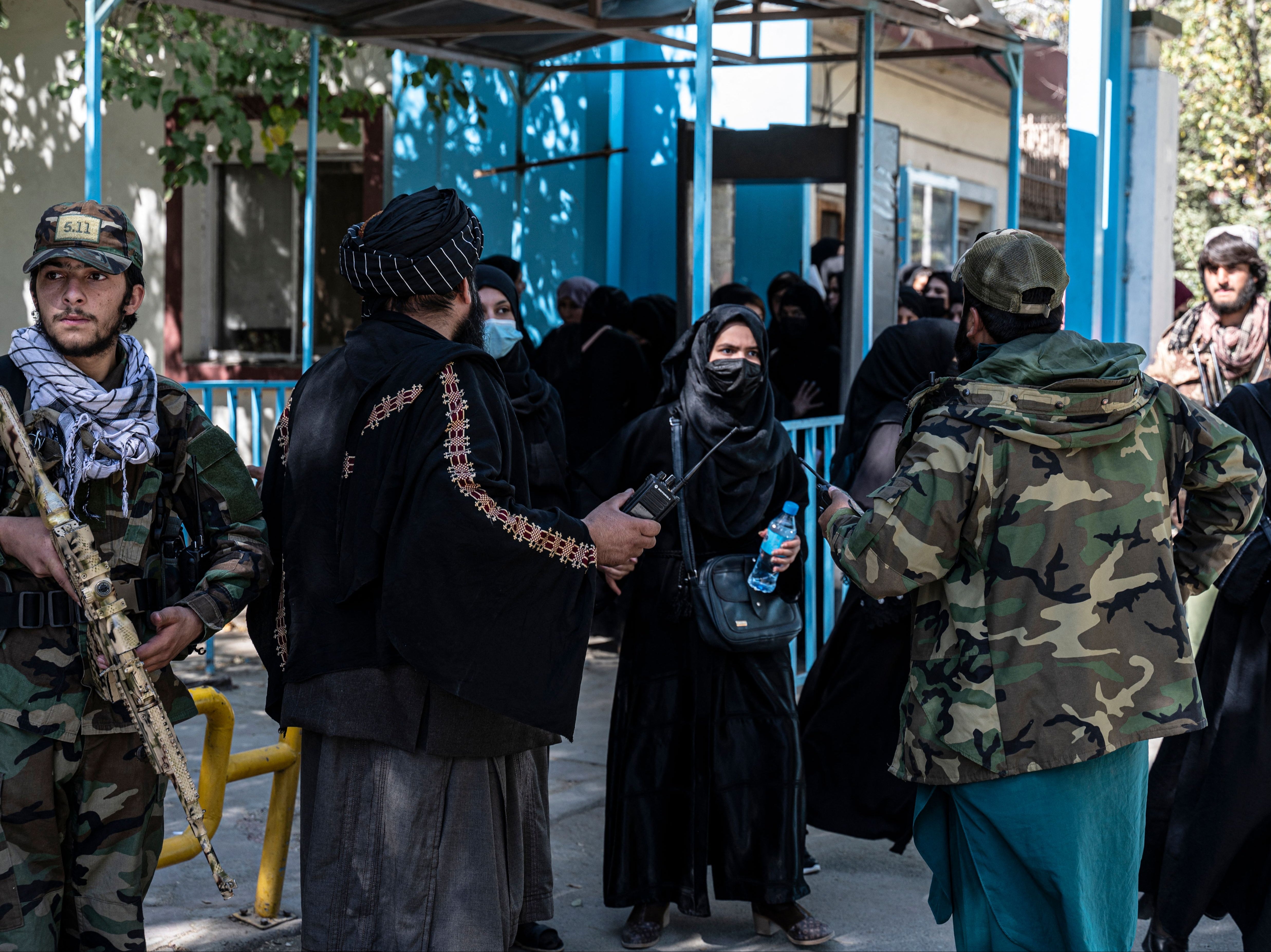 Taliban fighters stand guard as female students arrive for entrance exams at Kabul University in October