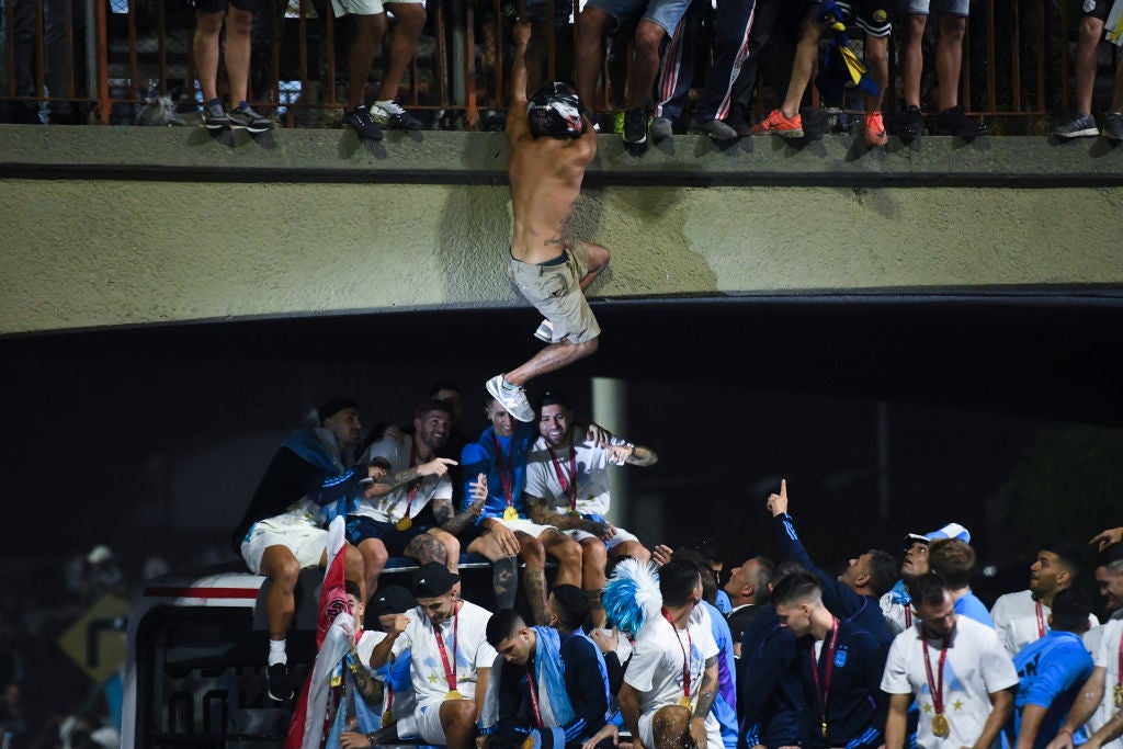 A fan jumps into the bus from an overhead bridge