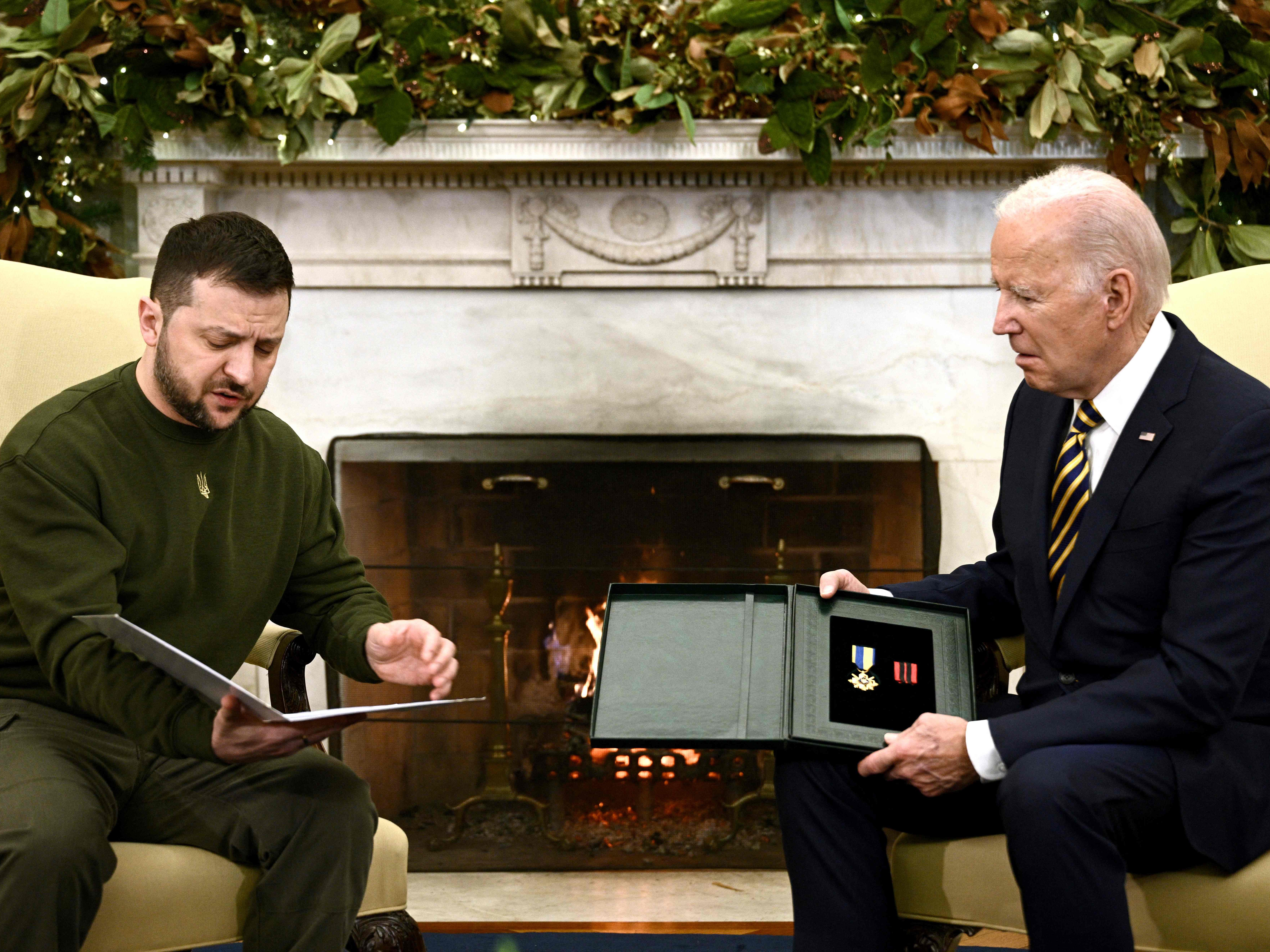 Ukraine's President Volodymyr Zelensky gives a medal to US President Joe Biden in the Oval Office of the White House, in Washington, DC on December 21, 2022