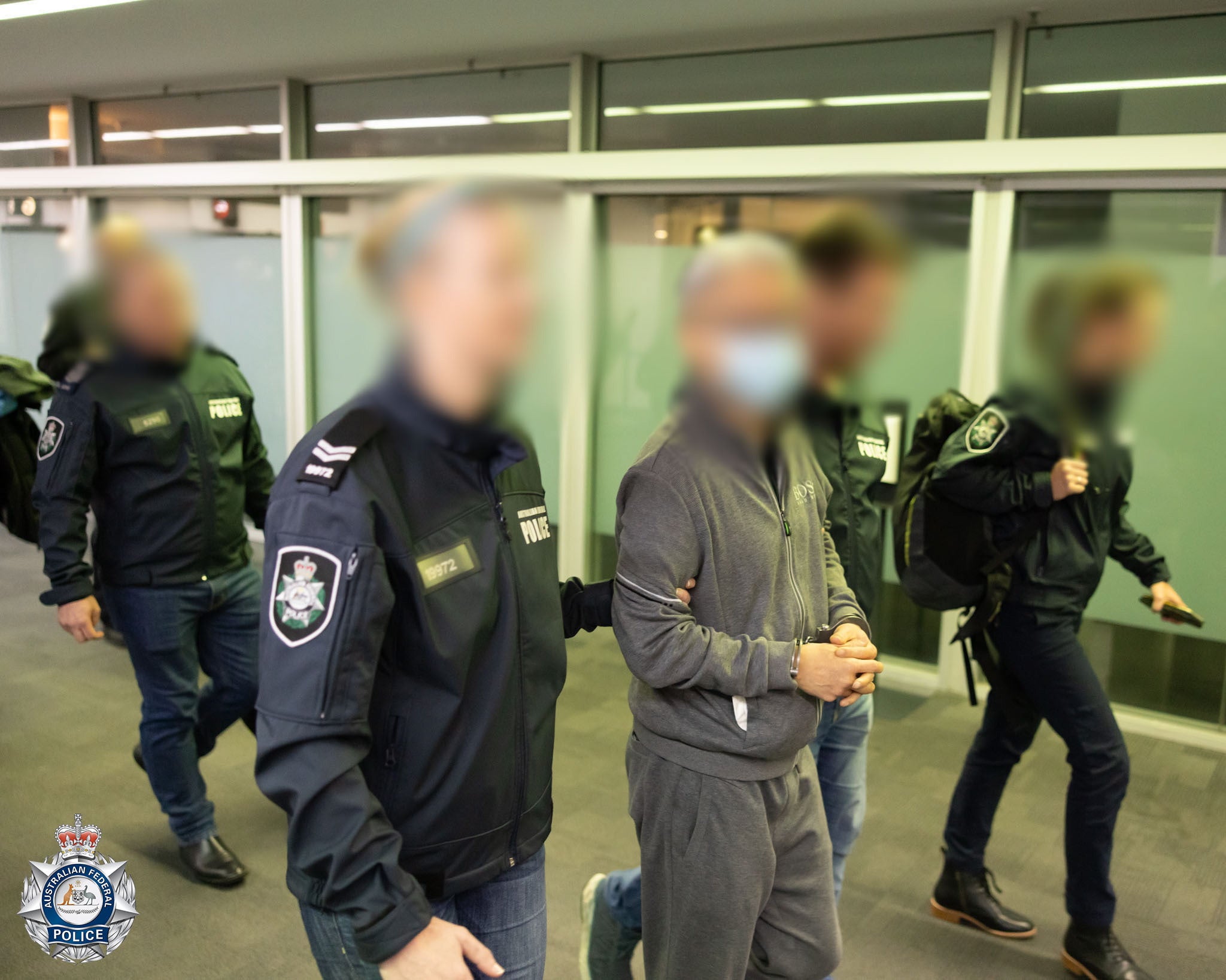 <p>File. Photo released by Australian police shows officers escorting Tse Chi Lop through the Melbourne airport after he was extradited from the Netherlands on 22 December 2022</p>