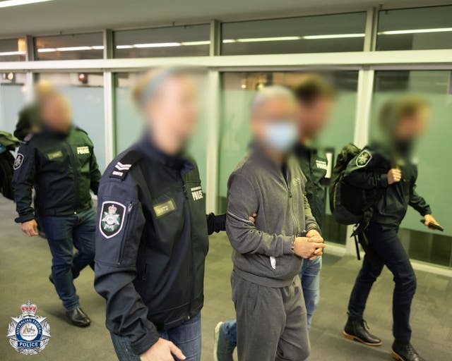 <p>File. Photo released by Australian police shows officers escorting Tse Chi Lop through the Melbourne airport after he was extradited from the Netherlands on 22 December 2022</p>