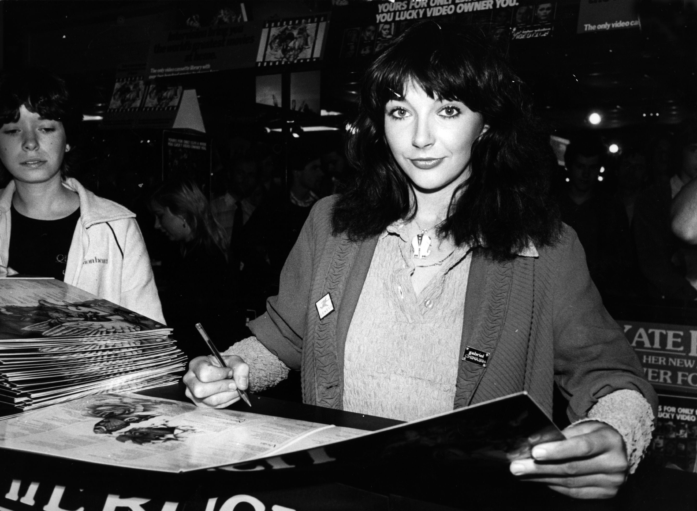 Kate Bush signing a vinyl copy of her album ‘Never For Ever’ in London, 1980