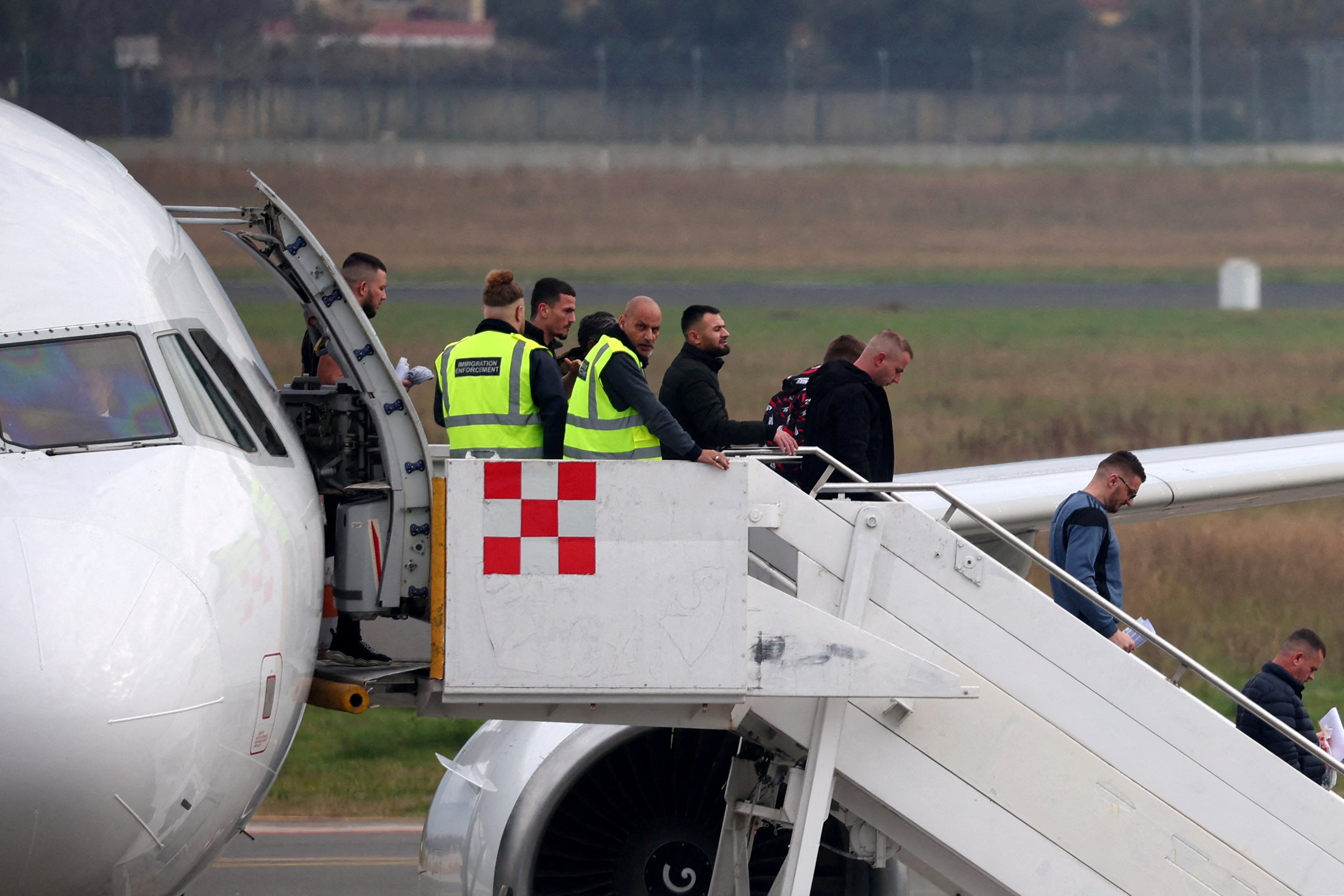 British immigration officers unload a plane at Tirana International Airport in the Albanian capital