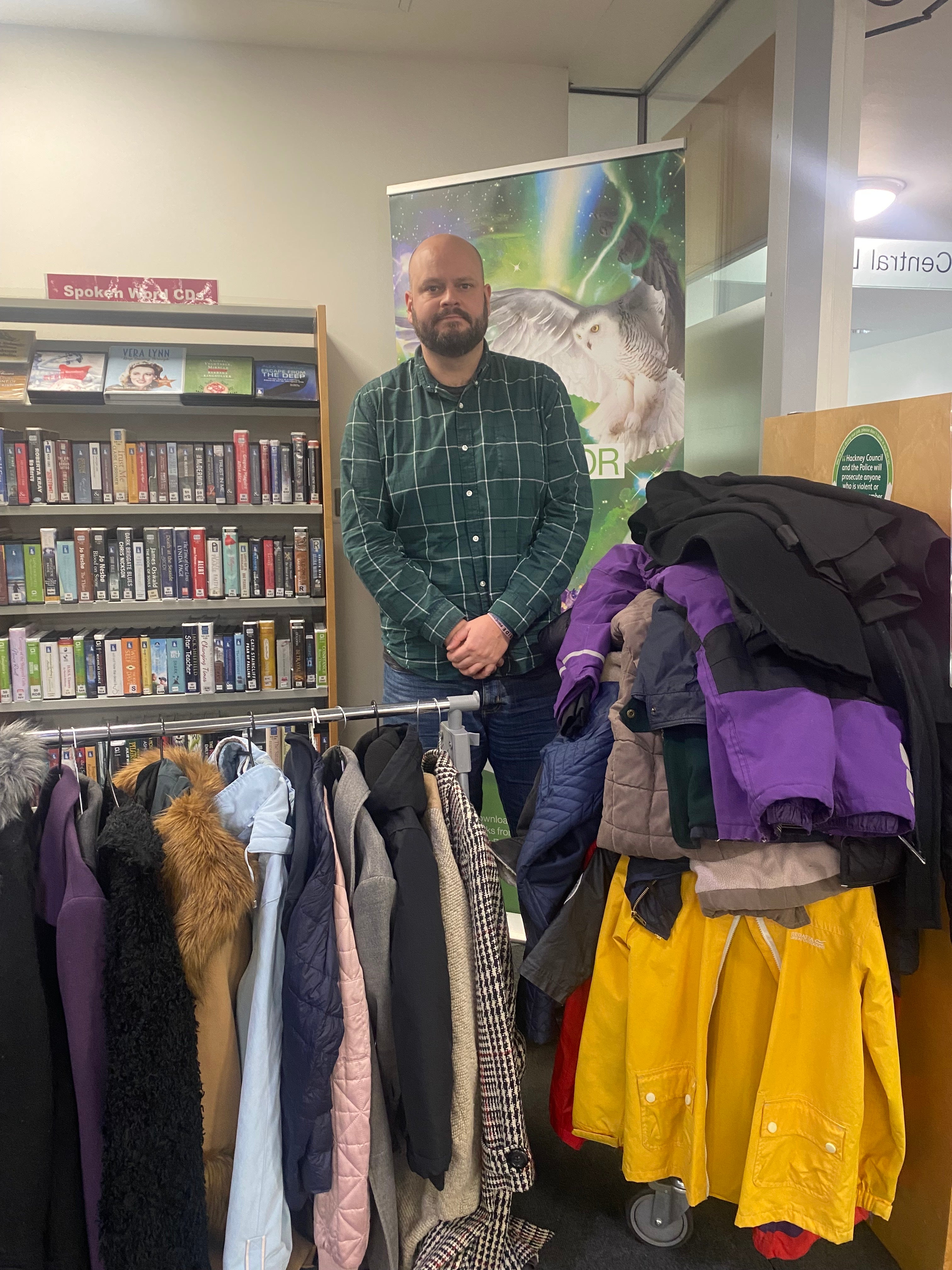 Mayor of Hackney Philip Glanville standing in front of a rail of donated coats