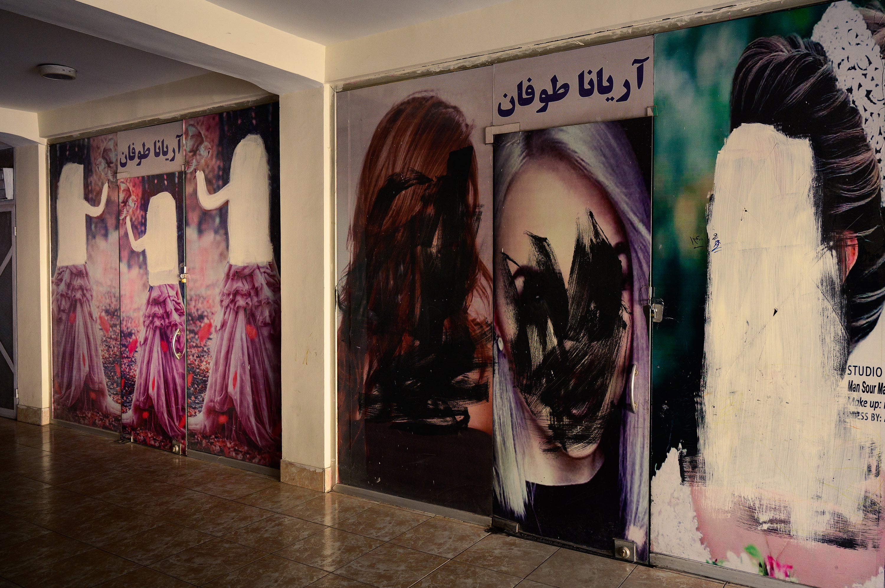 Women's faces have been painted over on the facades of beauty salons in Kabul's Khair Khana neighborhood