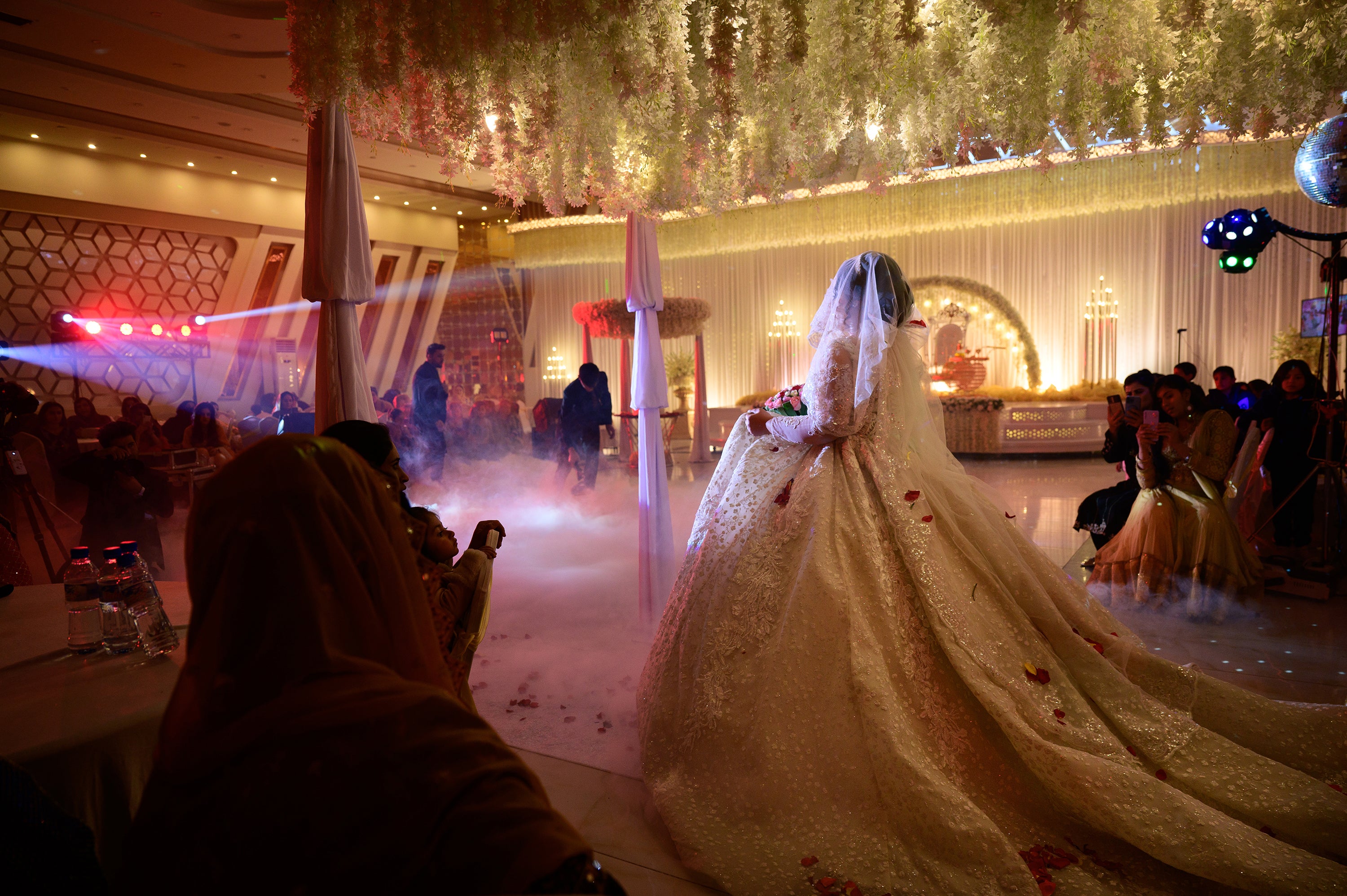 Sabrina reenters the reception hall in her third dress of the evening as hundreds of guests look on