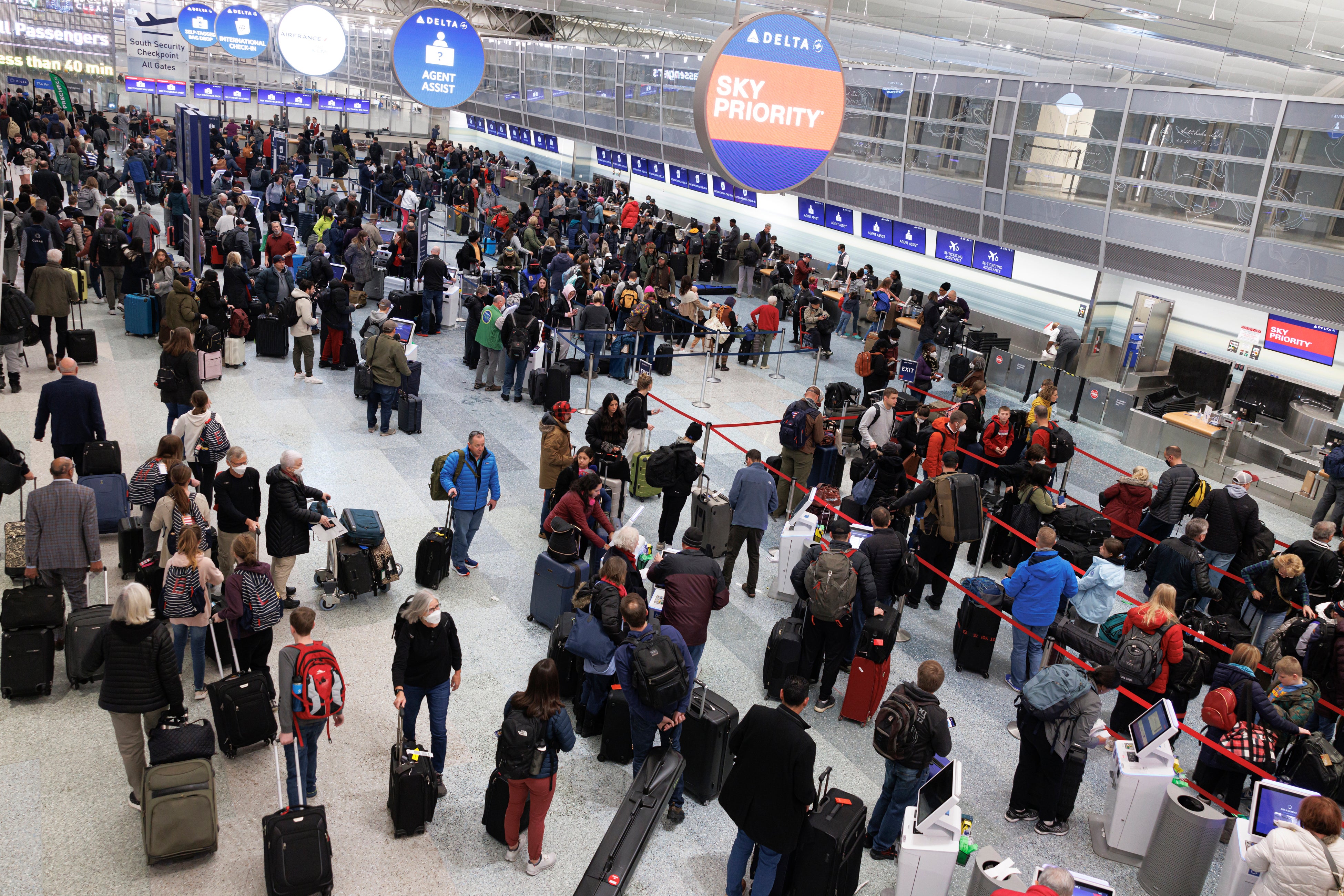 Travelers wait in line to check-in for their flights at Terminal 1 ahead of the Christmas Holiday at Minneapolis-St Paul Airport on Thursday