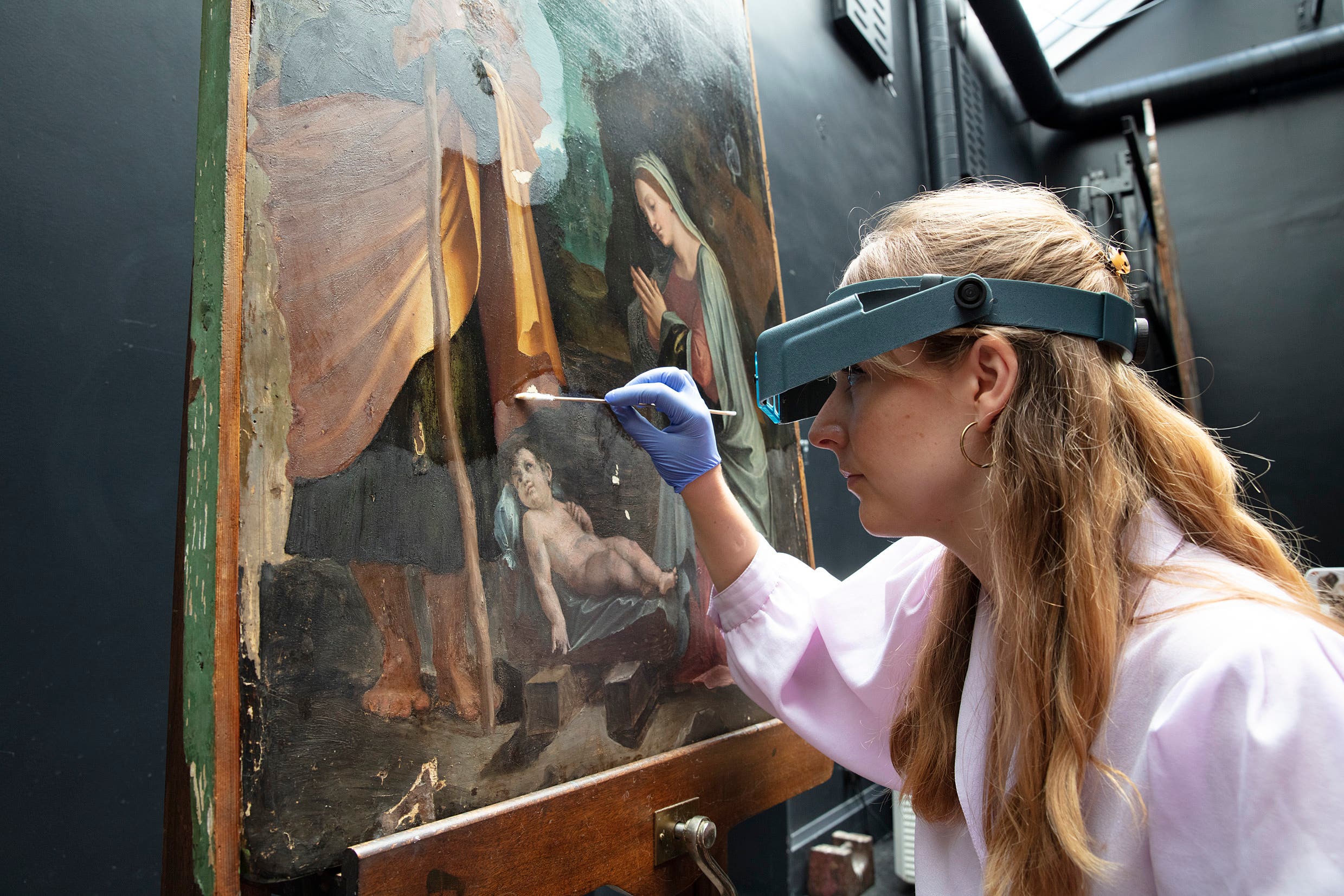 Conservationist Olivia Stoddart works on Peruzzi’s Nativity (The National Gallery, London/PA)