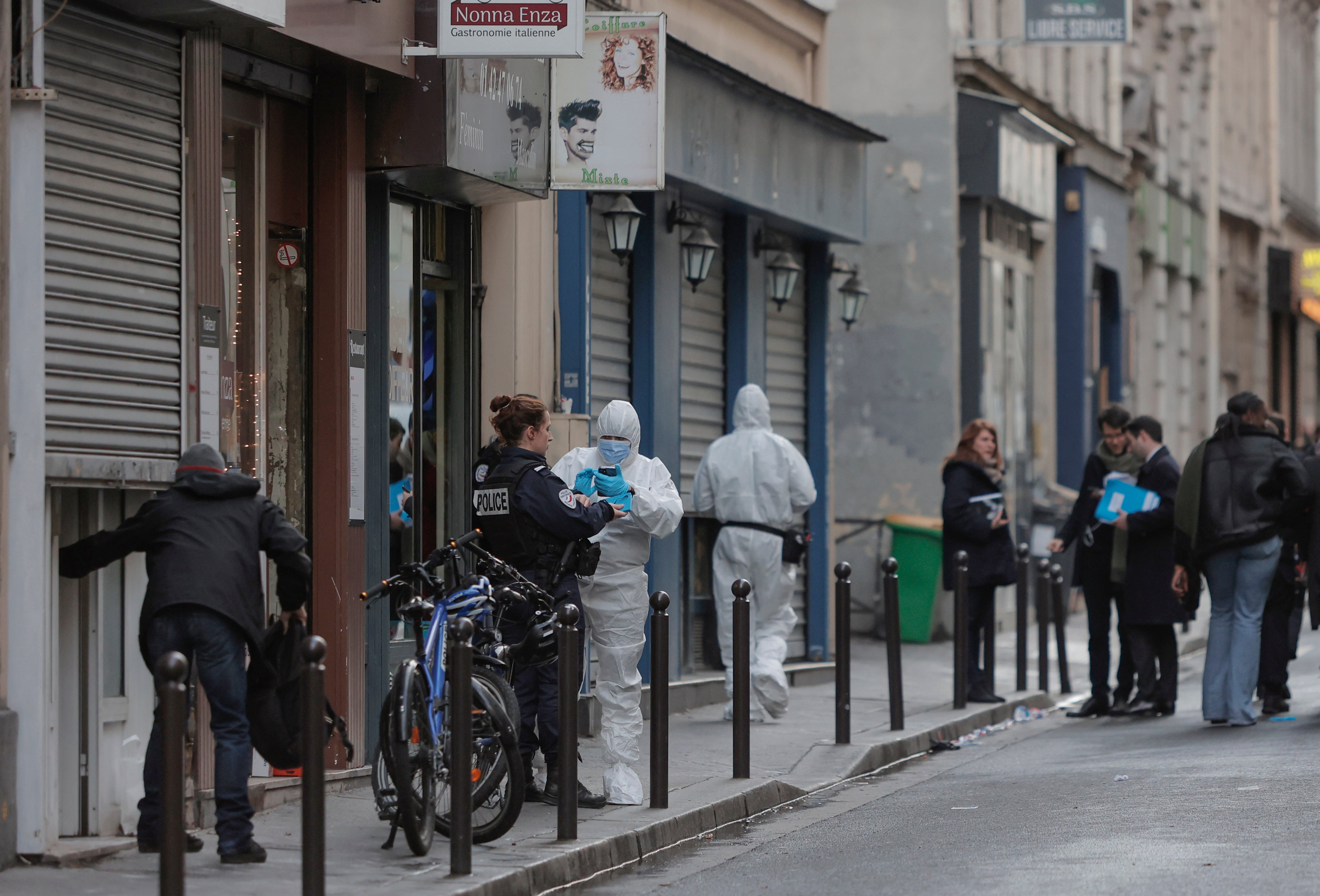 Police investigate at the scene where a shooting took place in Paris on 23 December