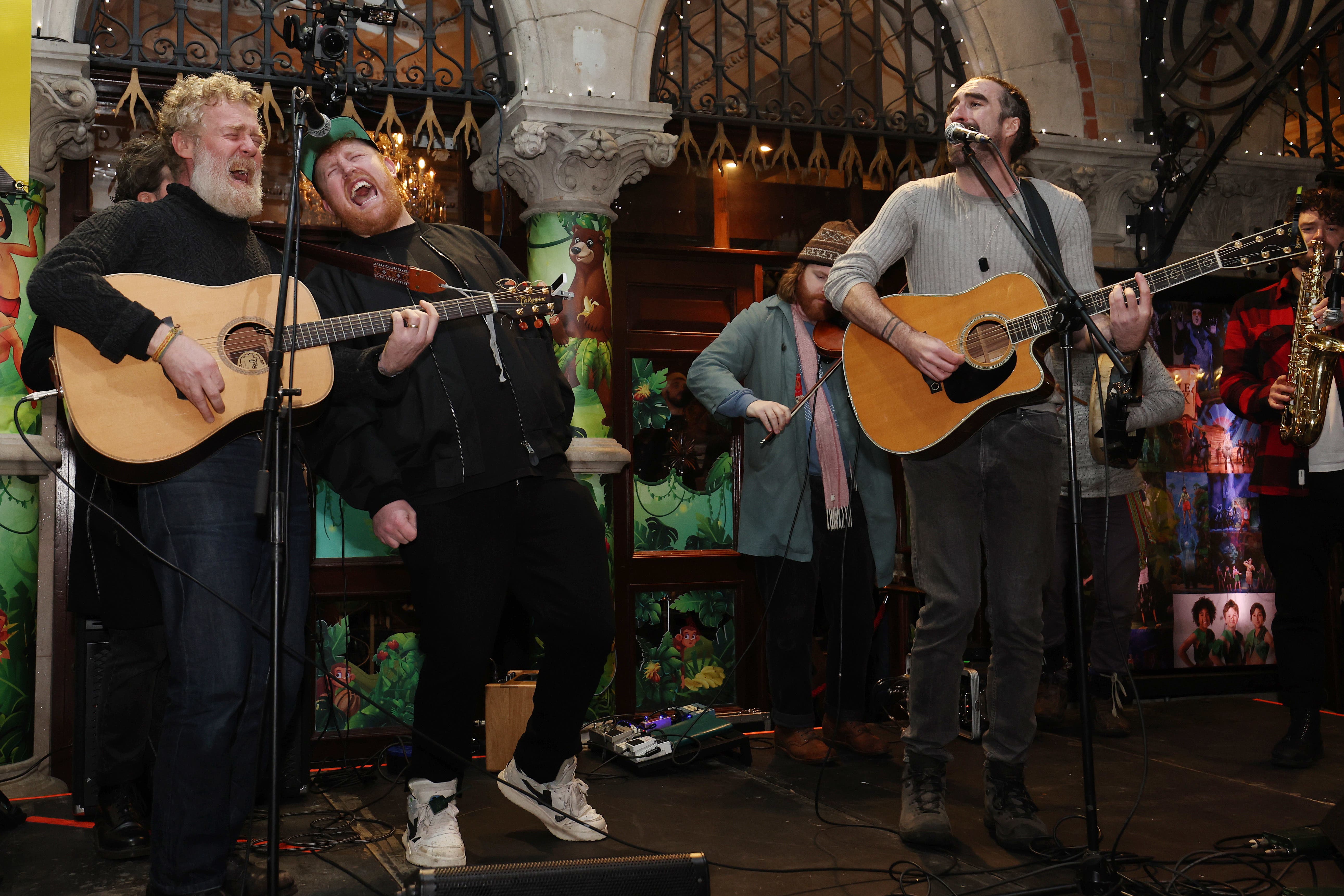 Glen Hansard, Gavin James and Danny O’ Reilly take part in the annual Christmas Eve busk on Grafton Street, Dublin (Lorrane O’Sullivan/PA)