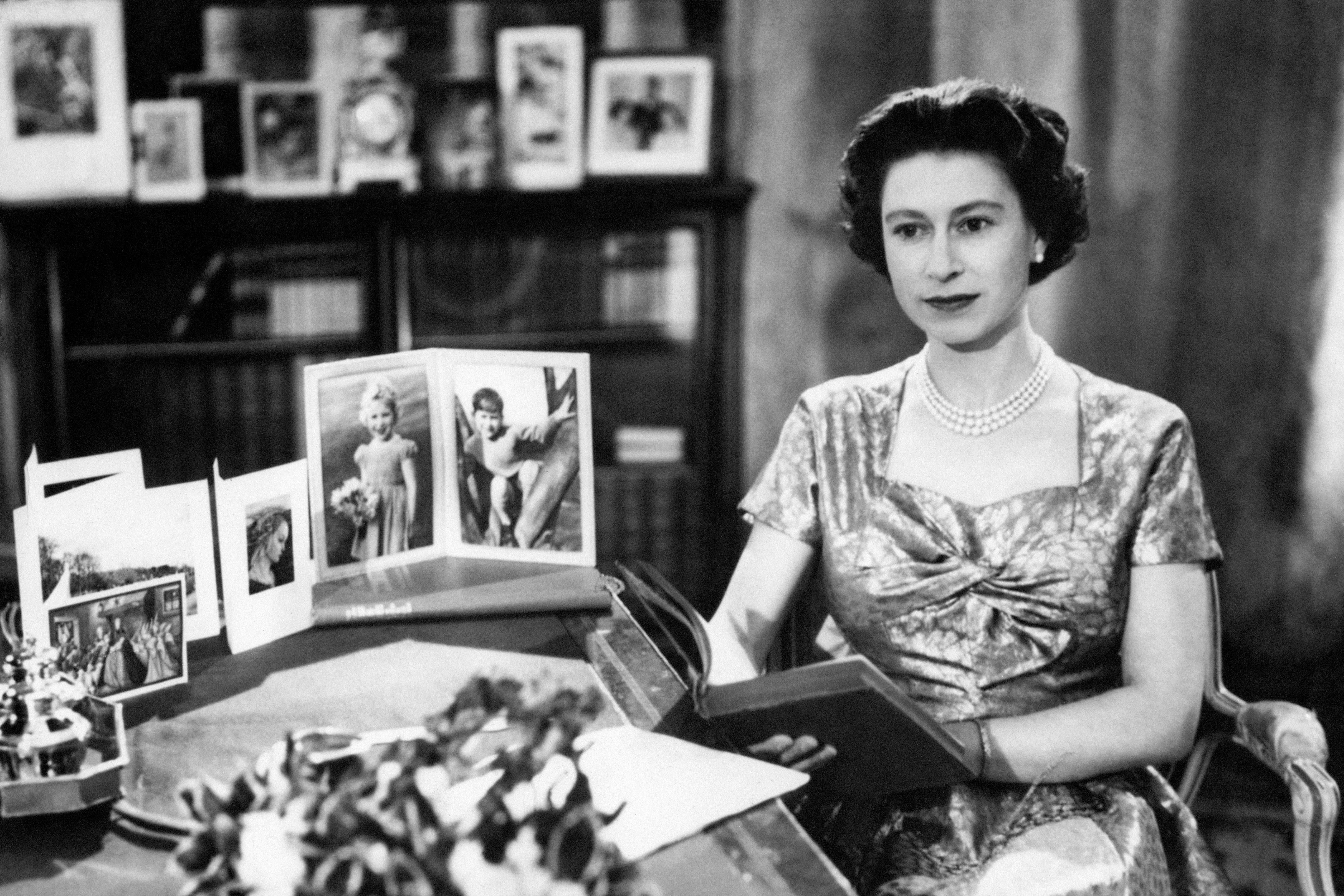 The Queen, in a gold lame dress, is seen in the Long Library at Sandringham shortly after making the traditional Christmas Day broadcast to the nation (PA)