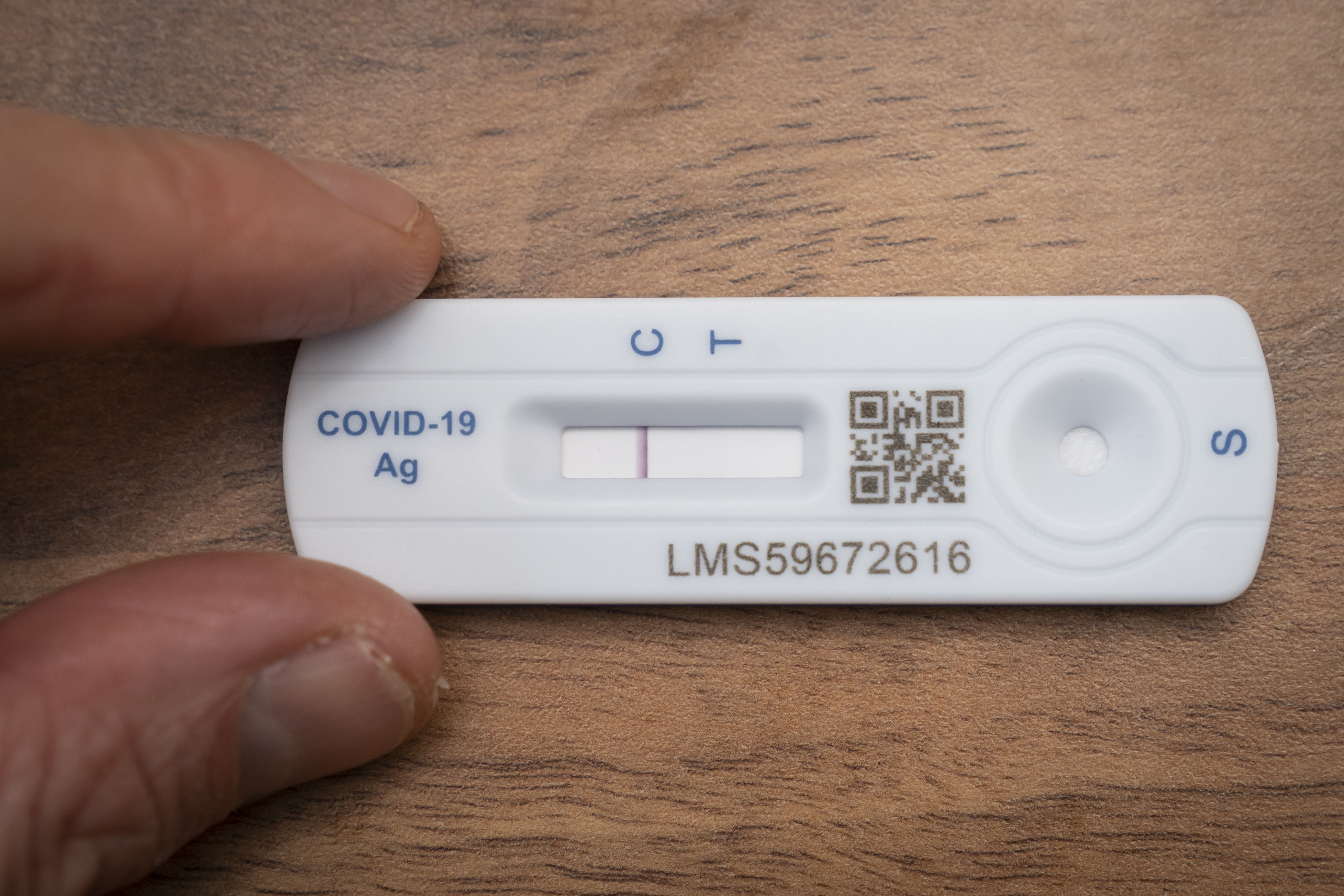 A person holding a Covid 19 lateral flow test (Danny Lawson/PA)