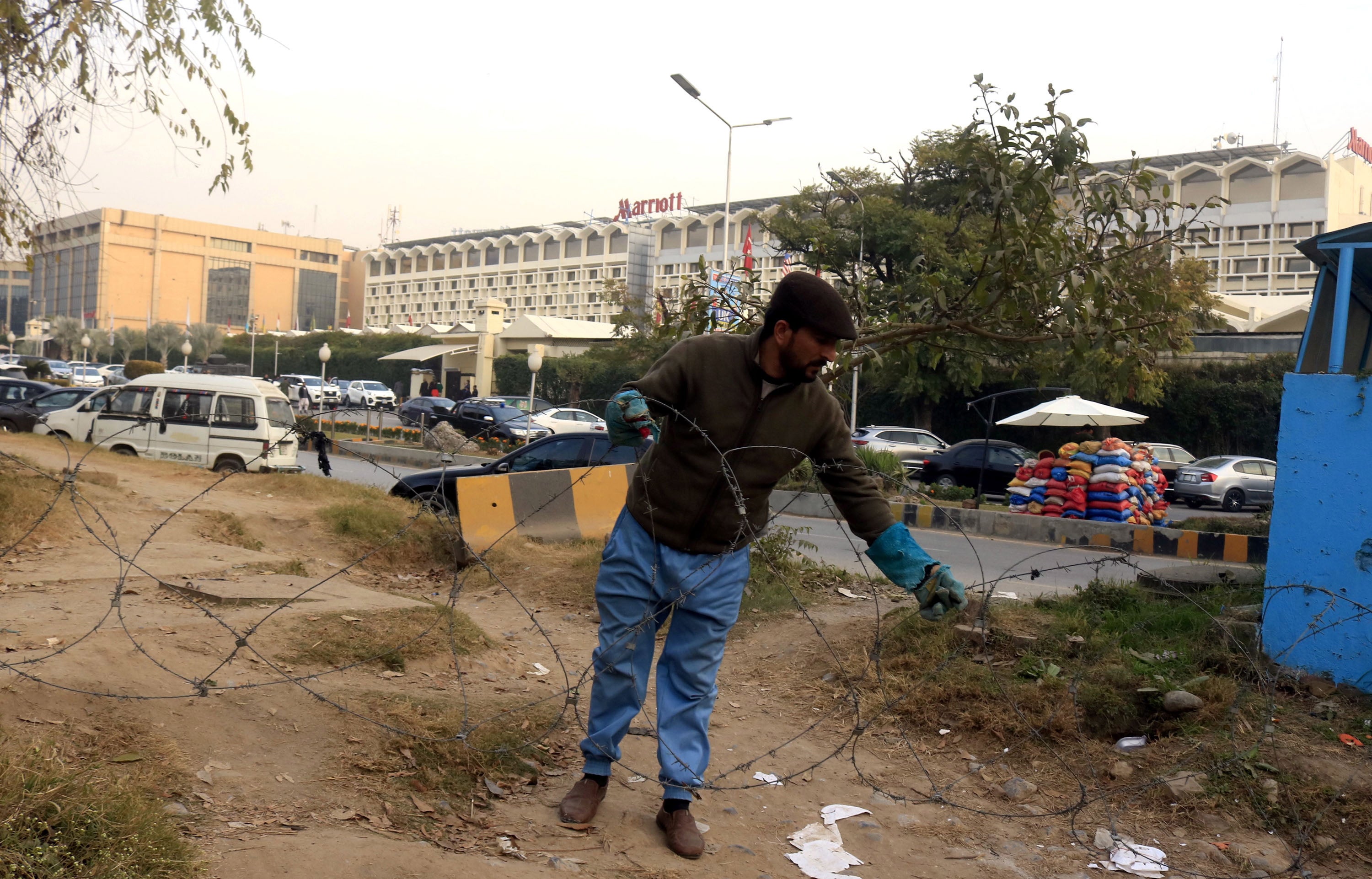 A laborer installs barbed wires outside the Marriott hotel in Islamabad on 26 December after the security alert