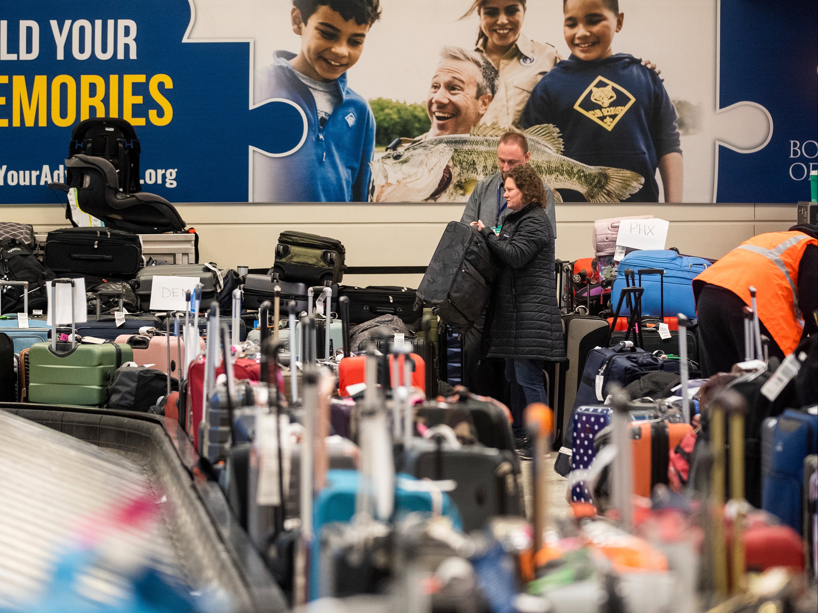 Brittany Kirk, 41, who arrived in Illinois on December 22 after a delayed flight from Denver, claims her lost luggage near the baggage carousel at Midway Airport in Chicago, Tuesday, Dec. 27, 2022,