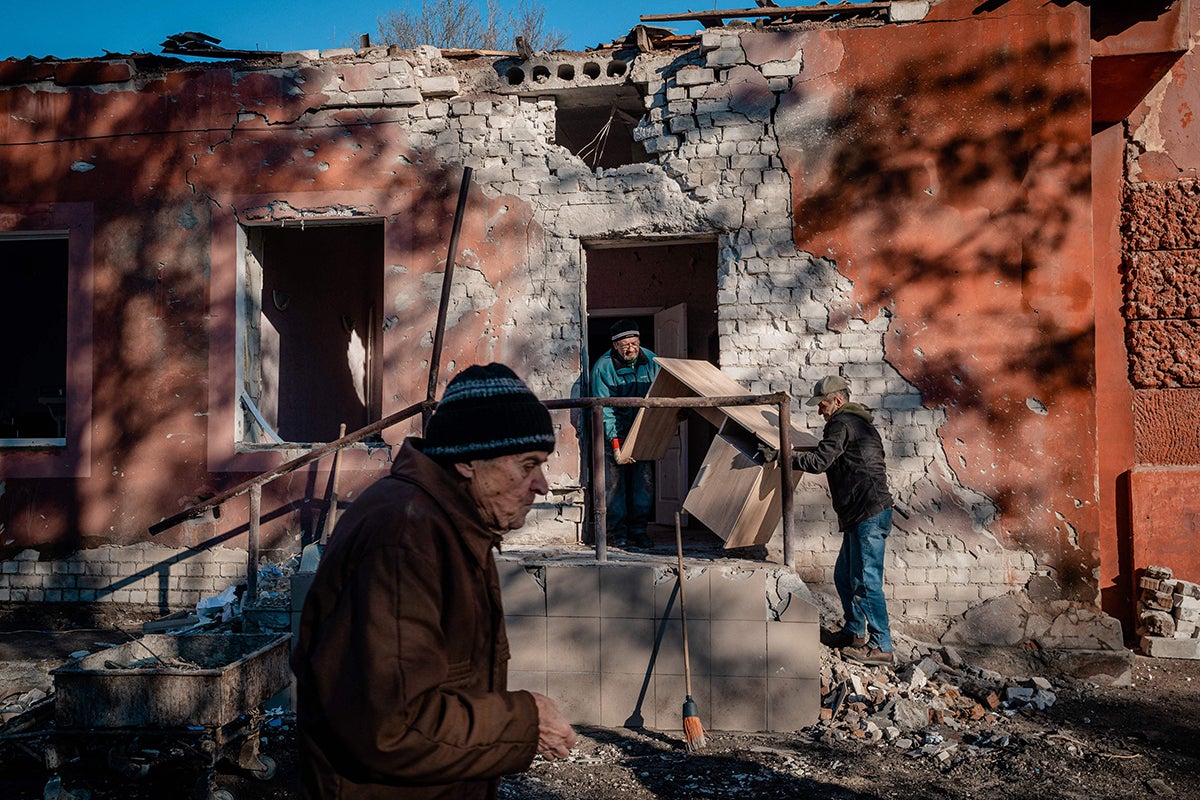 Workers carry furniture from the hospital maternity unit damaged after a Russian shelling in Kherson