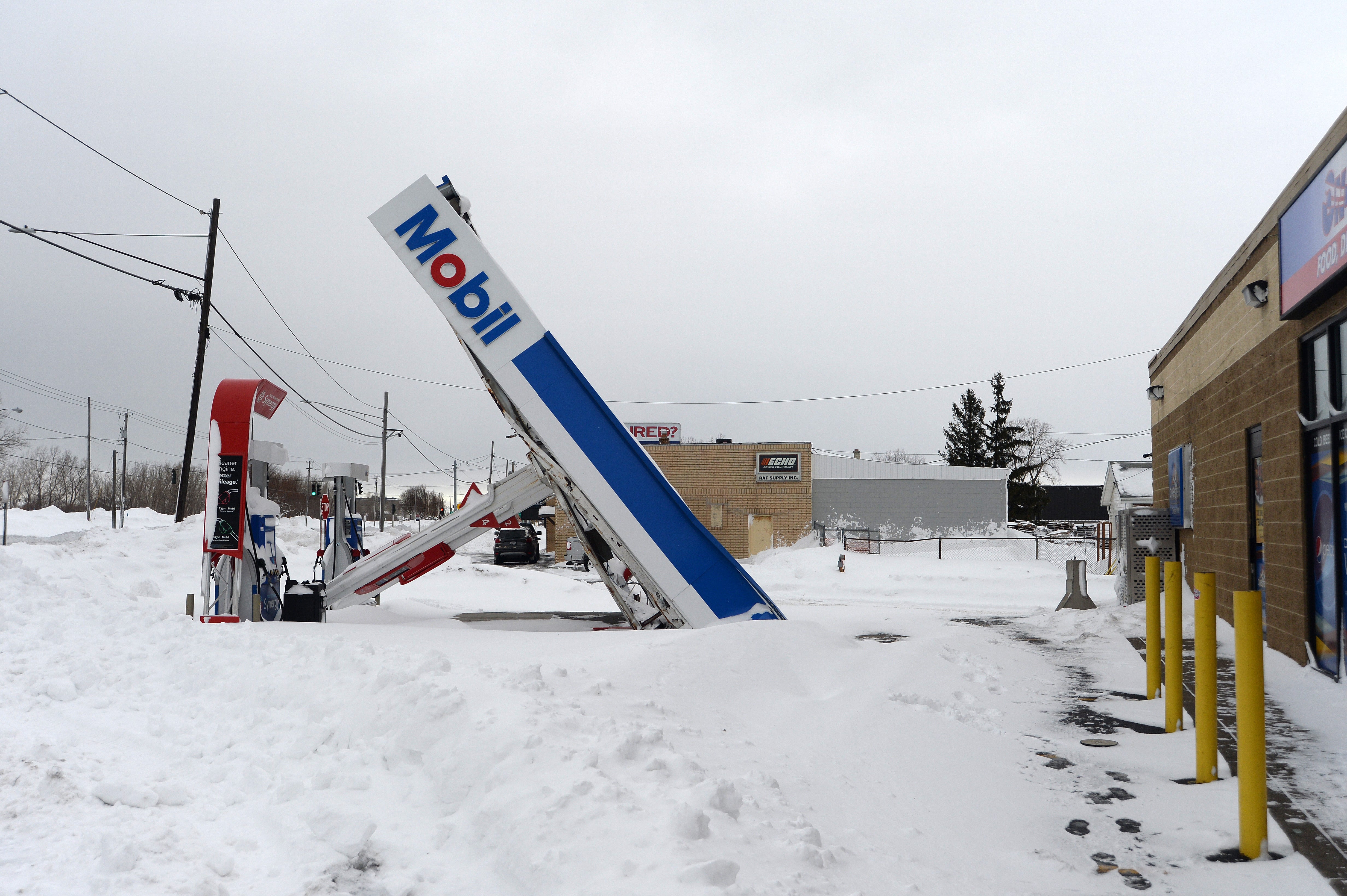 A gas station canopy lays on its side after high winds and heavy snow in Lackawanna, New York