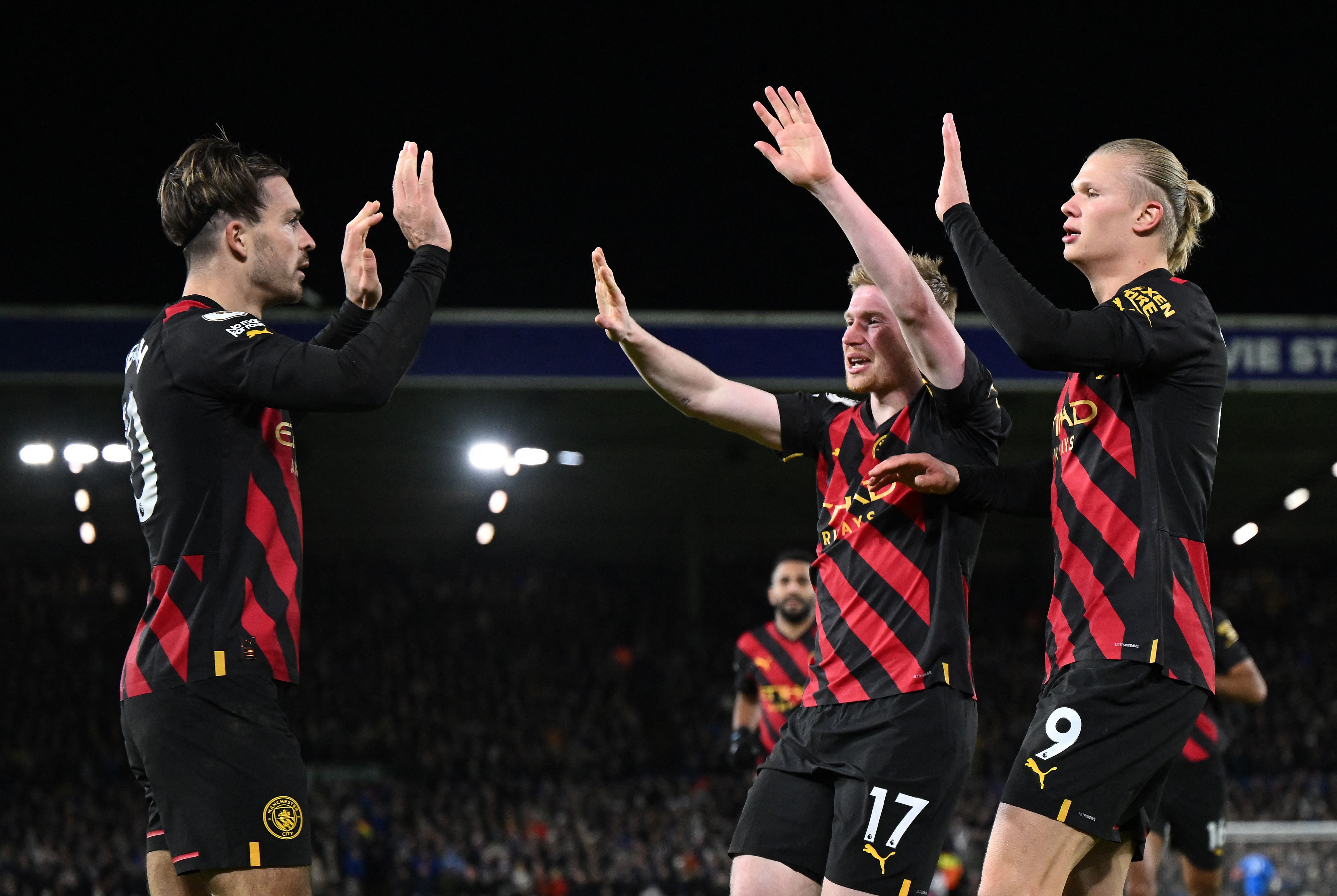 Jack Grealish celebrates with Kevin de Bruyne and Erling Haaland