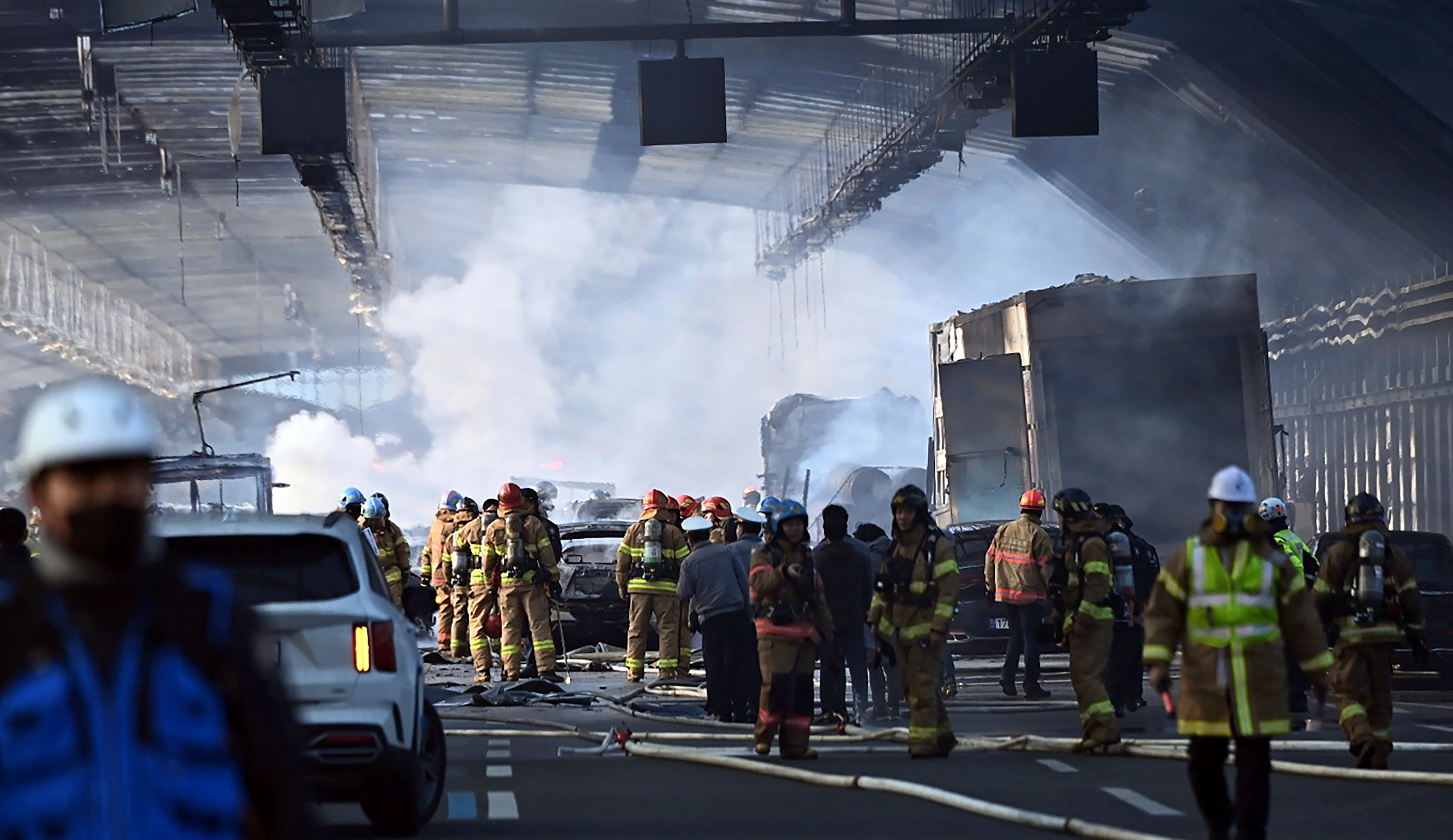 Firefighters work to extinguish a fire on a highway in Gwacheon, South Korea