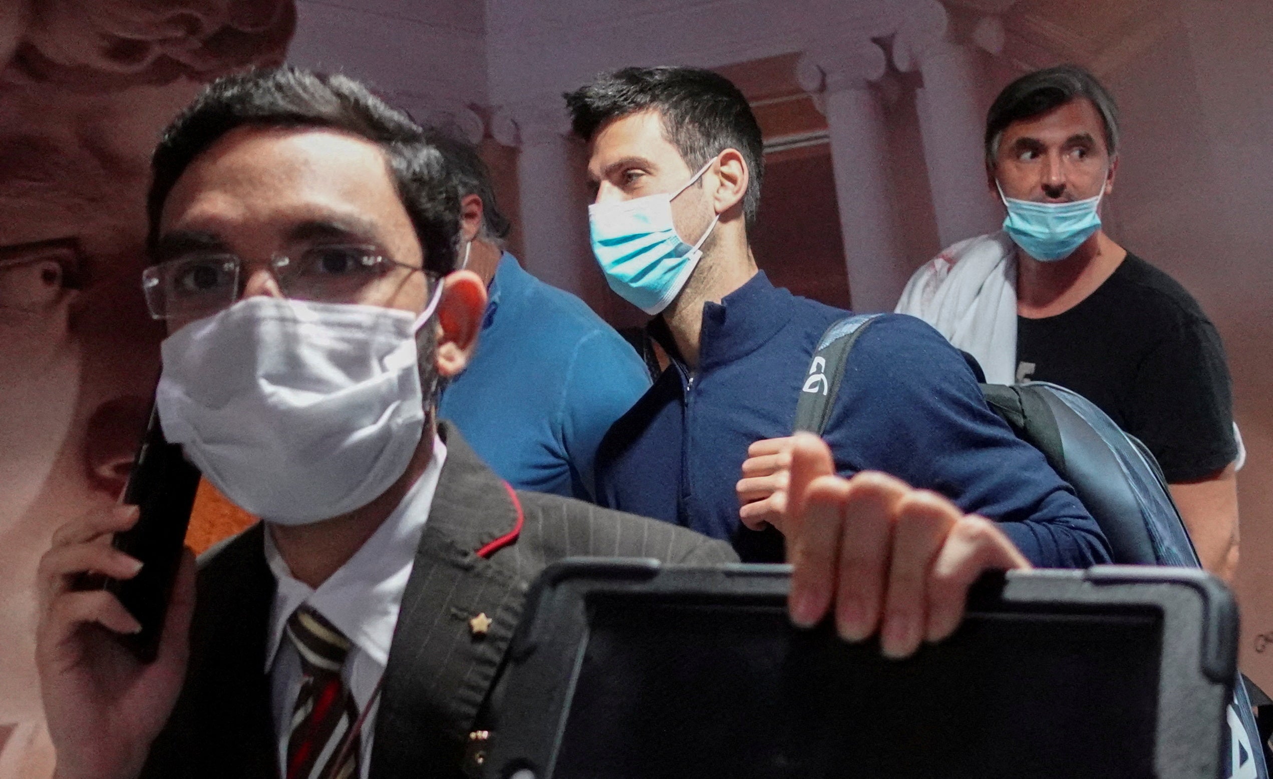 Serbian tennis player Novak Djokovic walks with his team after landing at Dubai Airport after the Australian Federal Court upheld a government decision to cancel his visa to play in the Australian Open