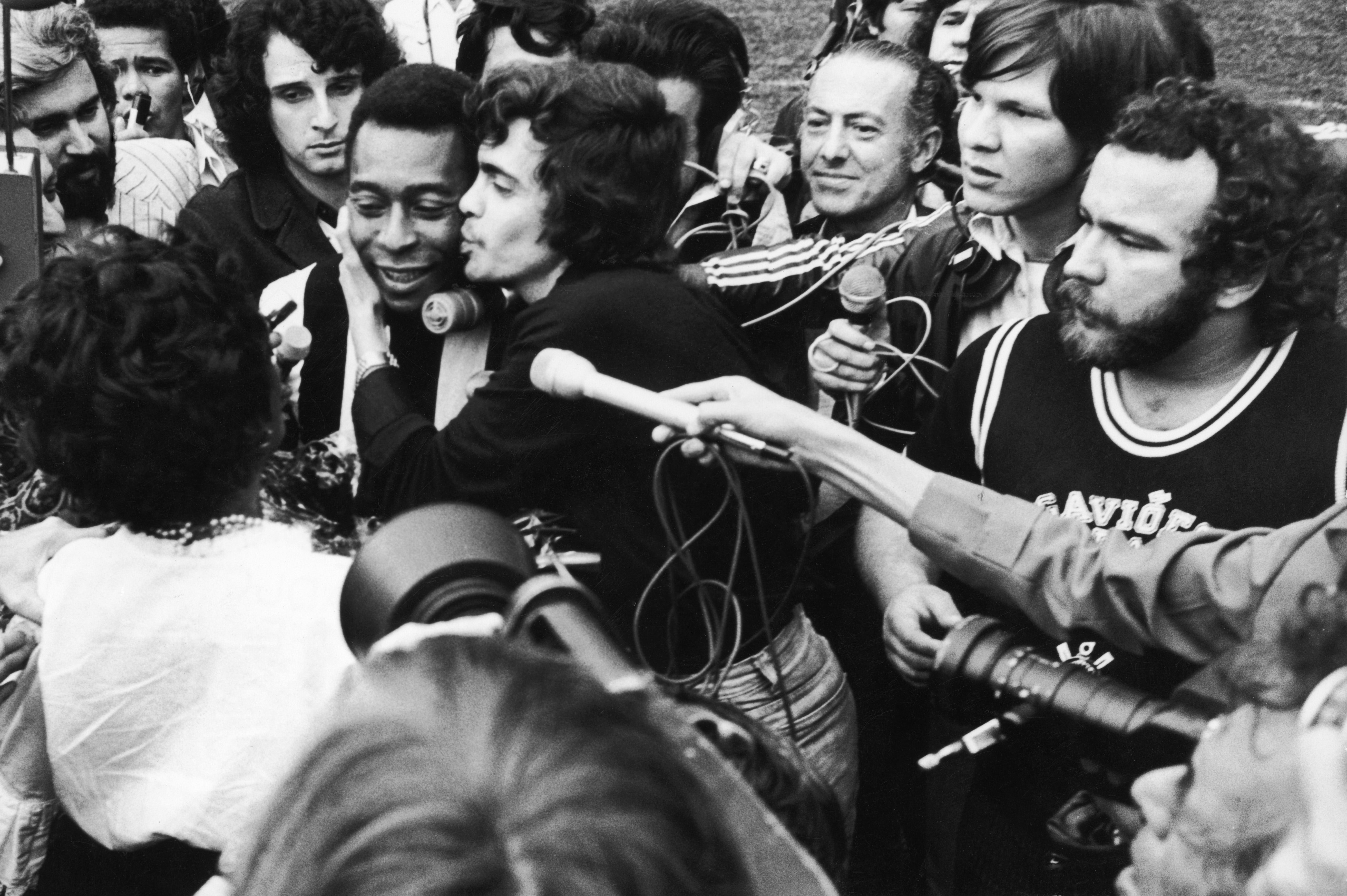 Pele is surrounded by players and press as he leaves the pitch after his last match in an 18 year spell at Santos, 8th October 1974. He retired from the game, Santos vs Ponte Preta, due to a thigh injury.