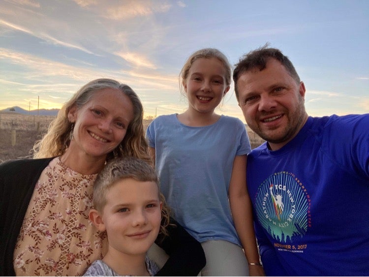 Mel Glover, left, poses with her husband and two children; the family lost their home and several pets in the Marshall Fire