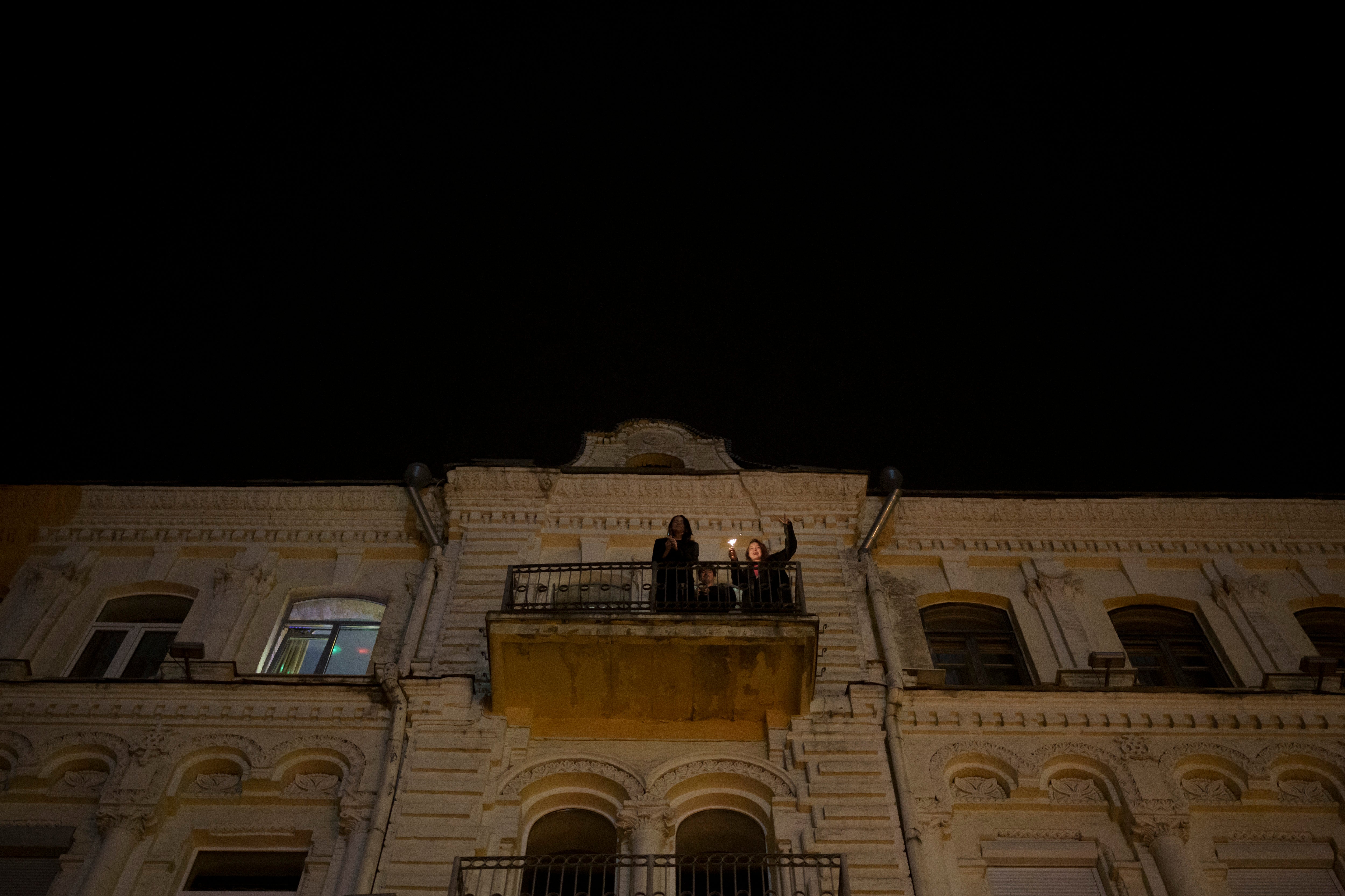 Ukrainians celebrate the New Year from their balcony during curfew in Kyiv