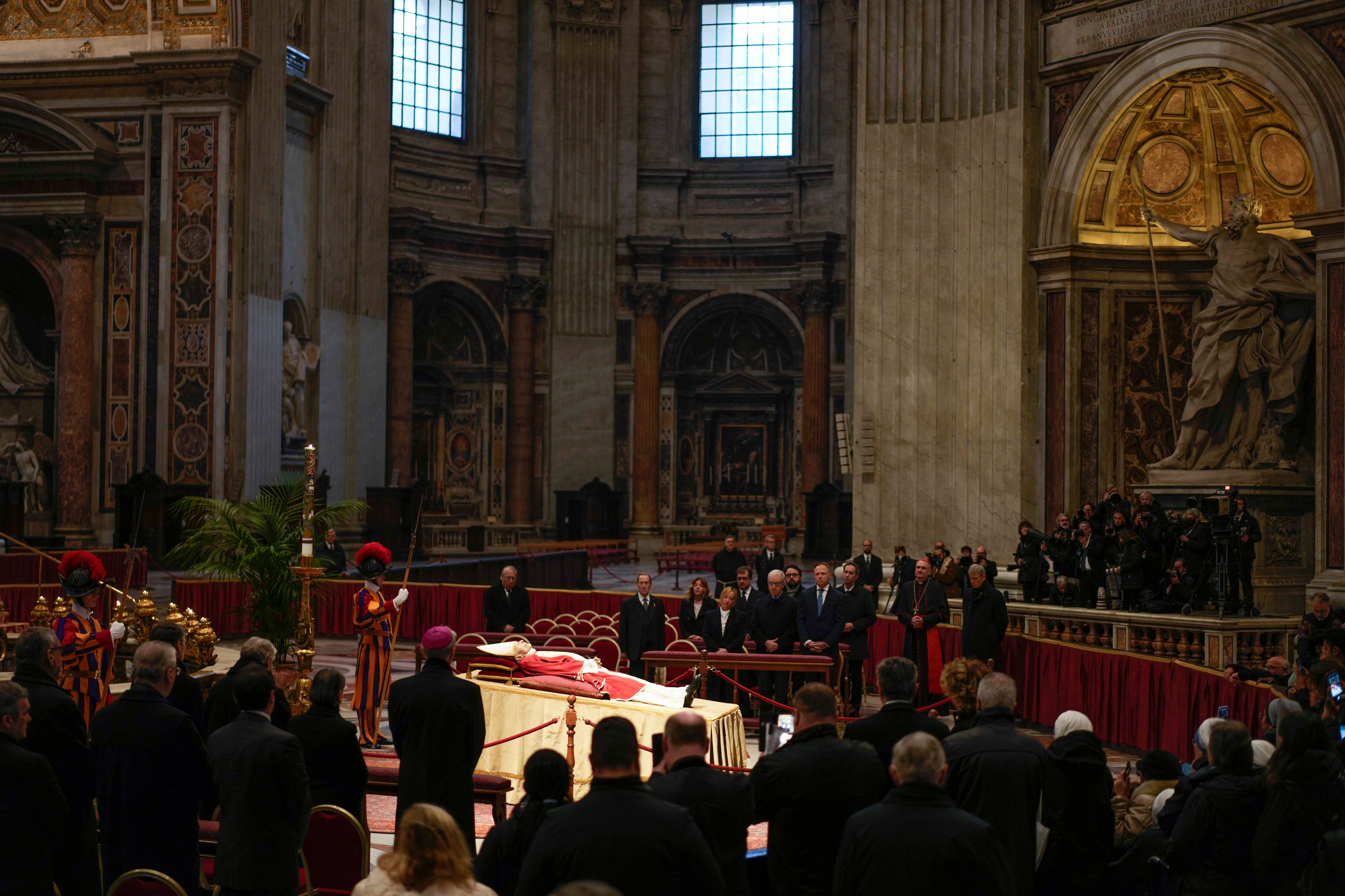 Mourners look at the body of the late former Pope Benedict XVI laid out in state inside St Peter’s Basilica