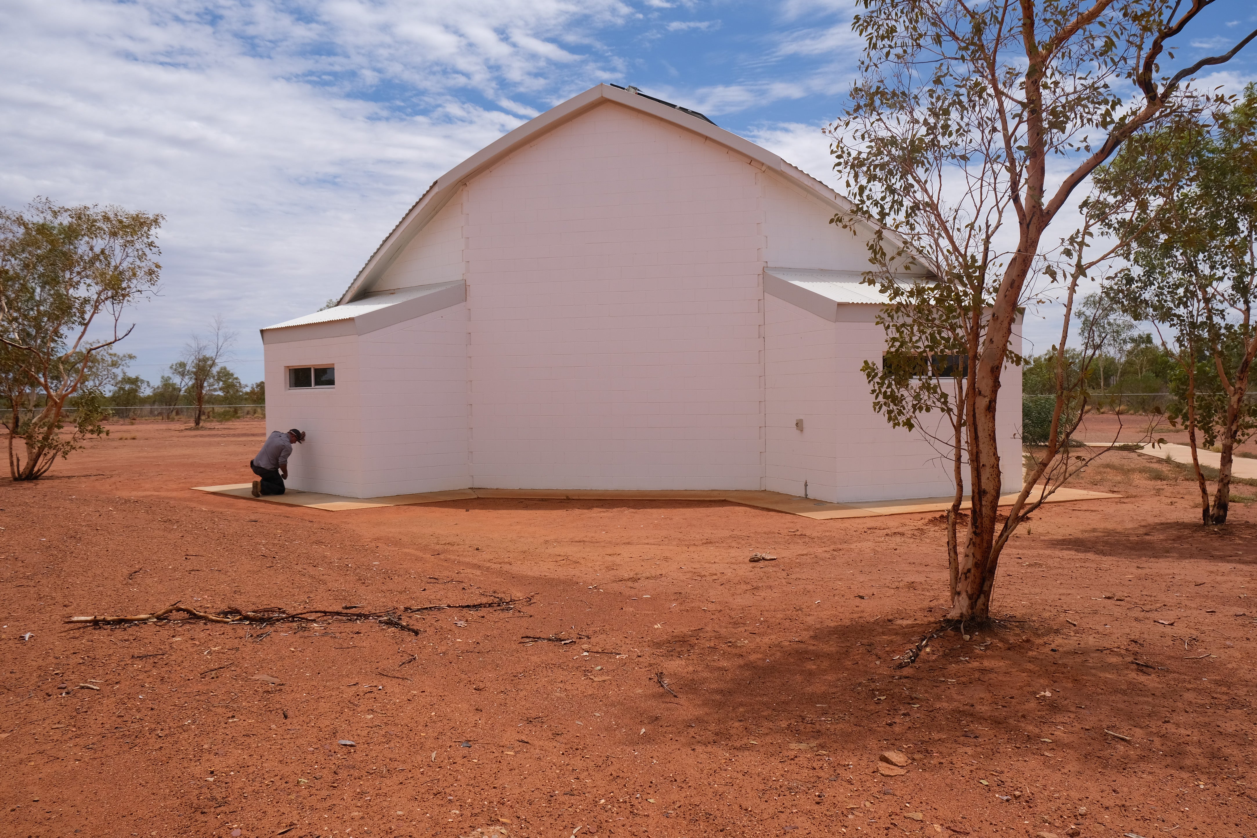 Chris Cook checks on a termite barrier system ringing a chapel in town