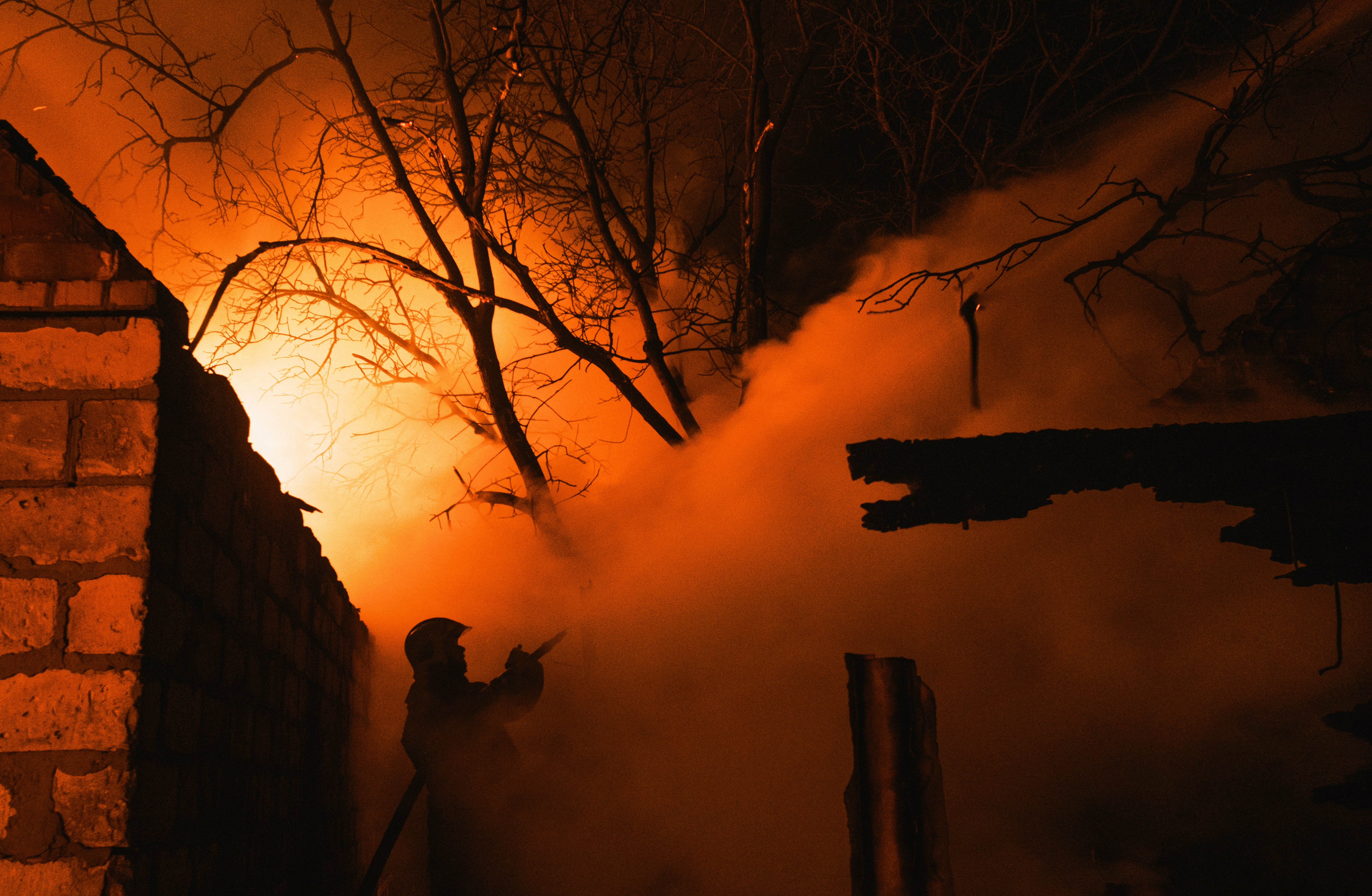 A rescuer tries to put out a fire of a private building after a Russian shelling in the Ivanivka village near Bakhmut of the Donetsk area, Ukraine