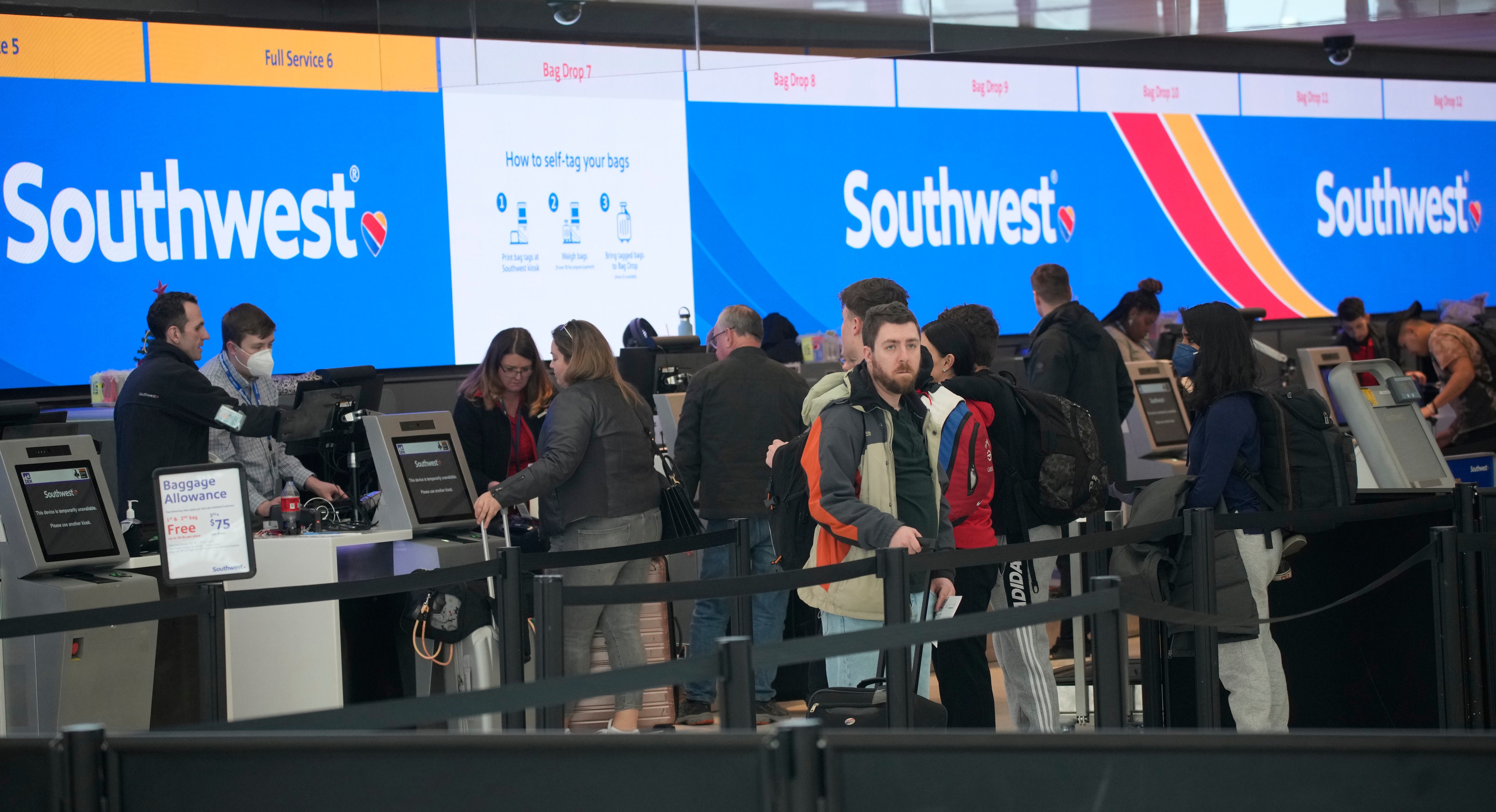 Travelers queue up at the check-in counters for Southwest Airlines in Denver International Airport on 30 December