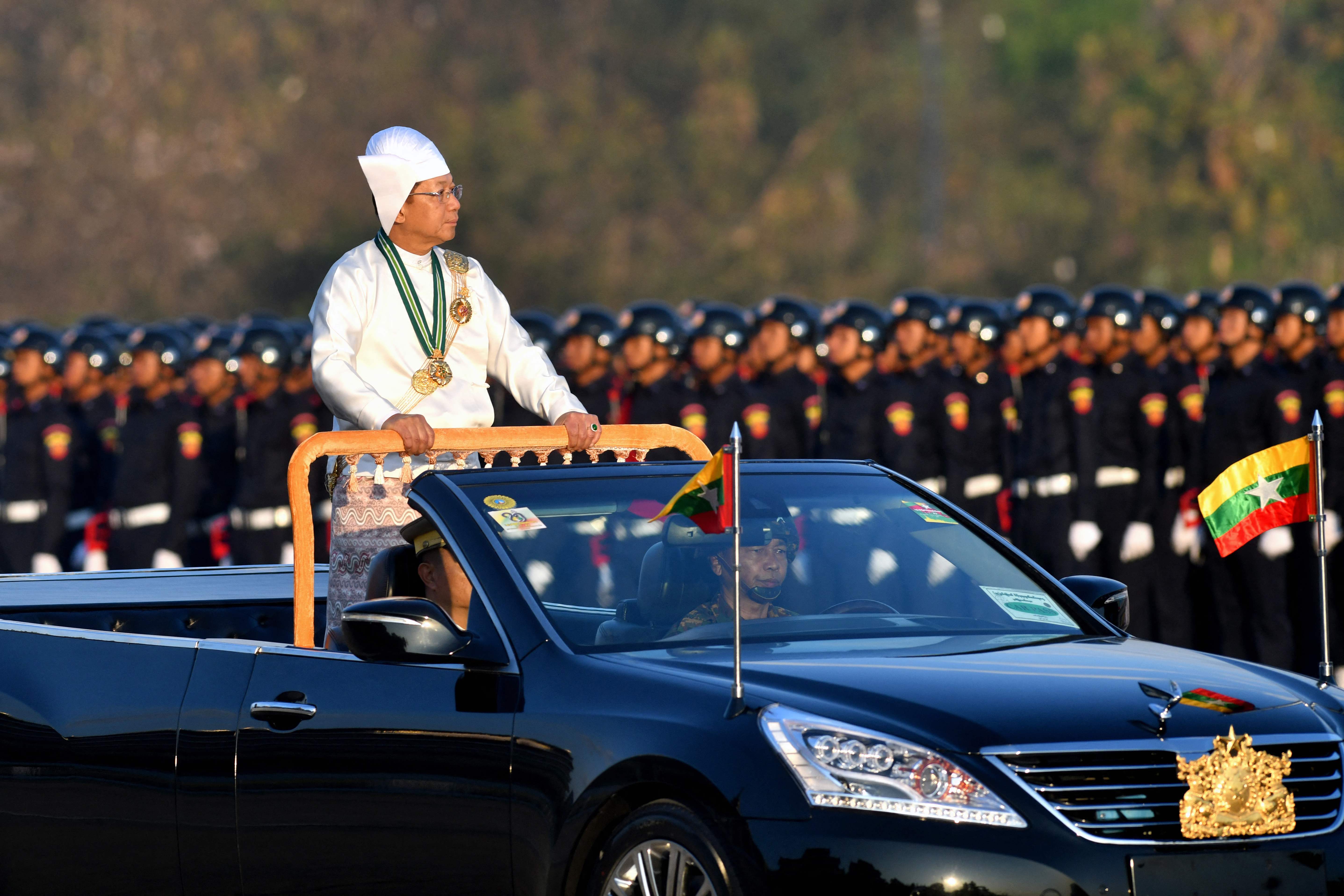 Myanmar's military chief Min Aung Hlaing stands in a car as he oversees a military display